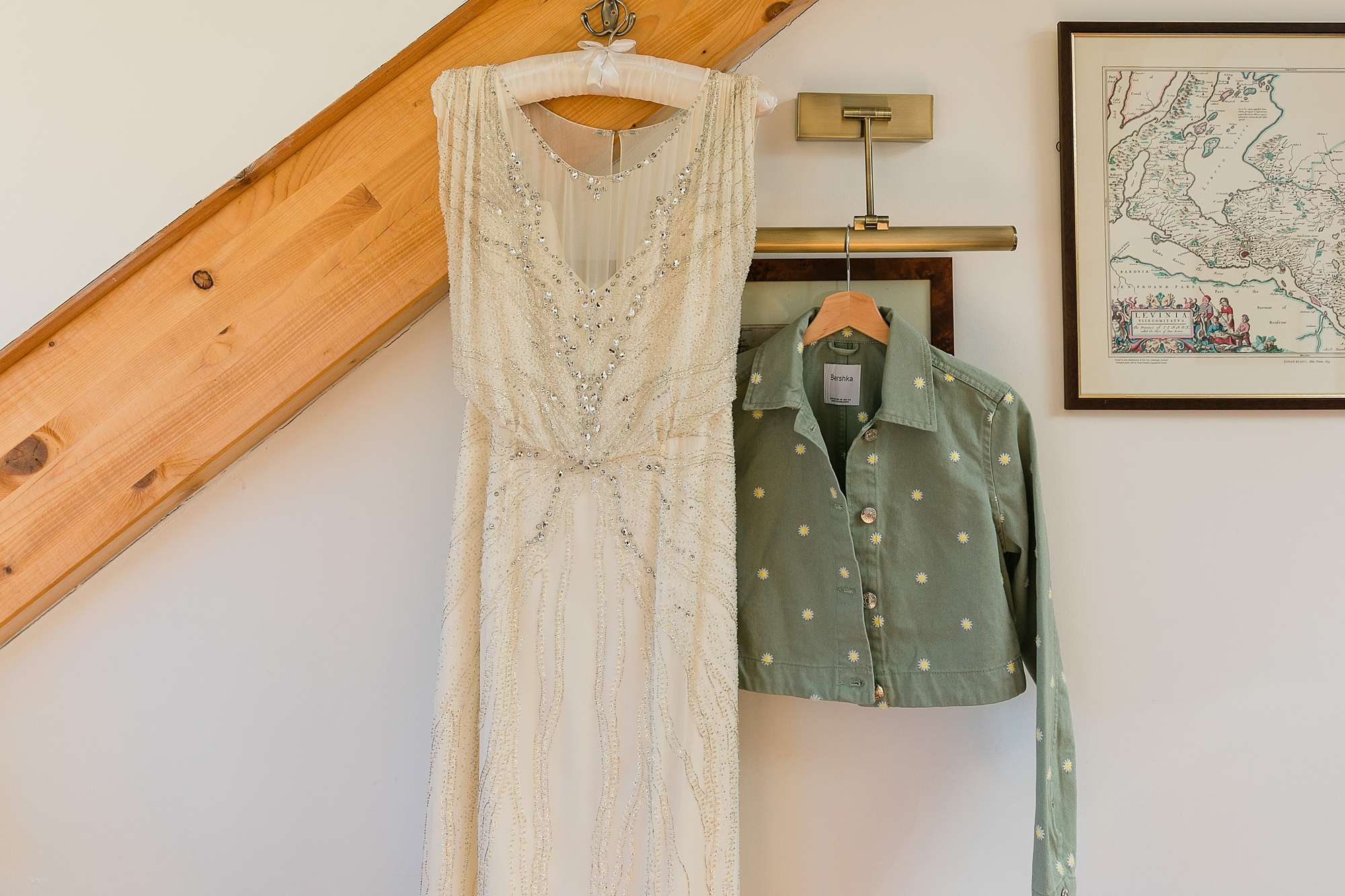 wedding dress and short green denim jacket hanging up