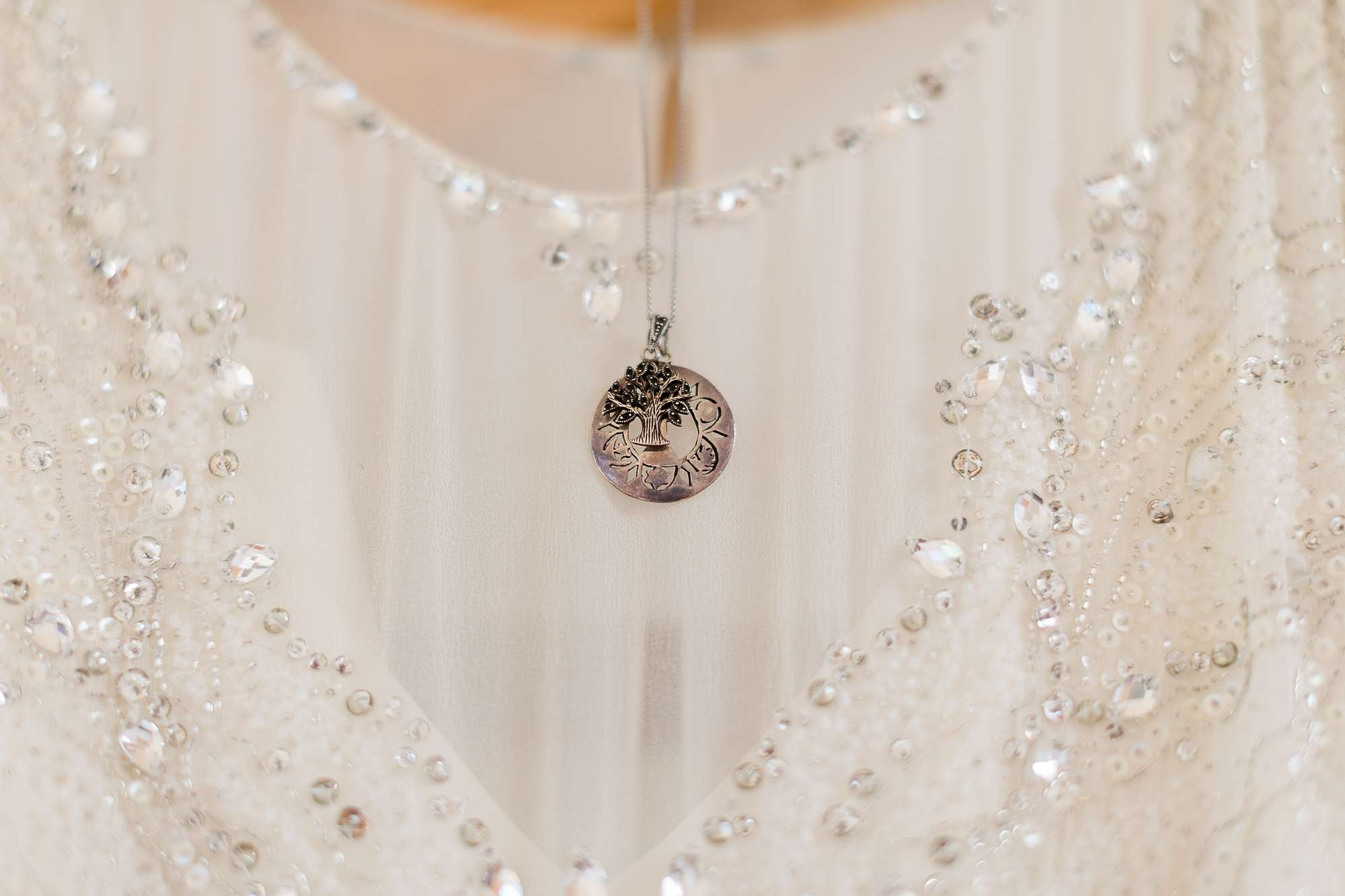 wedding necklace hanging next to wedding dress neckline