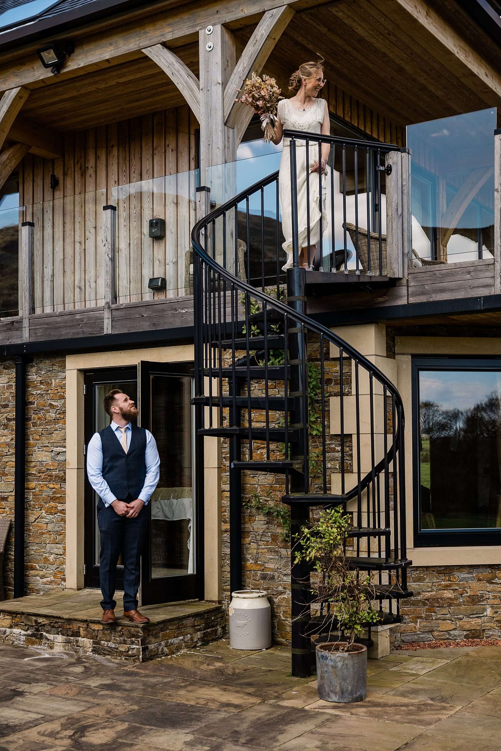 groom standing at the bottom of a black spiral staircase at Carrick castle estate waiting for his bride