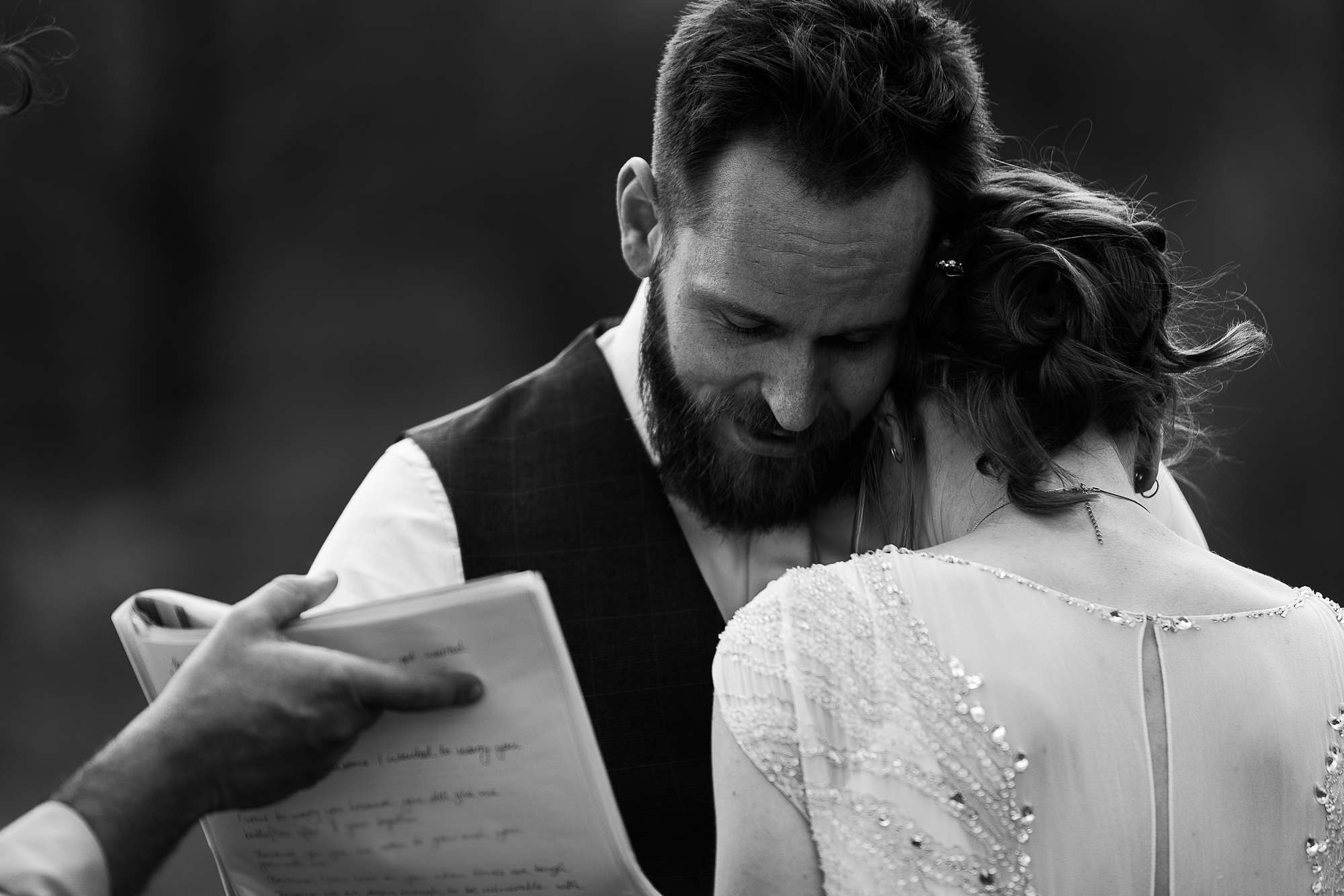 groom cuddling bride during wedding ceremony