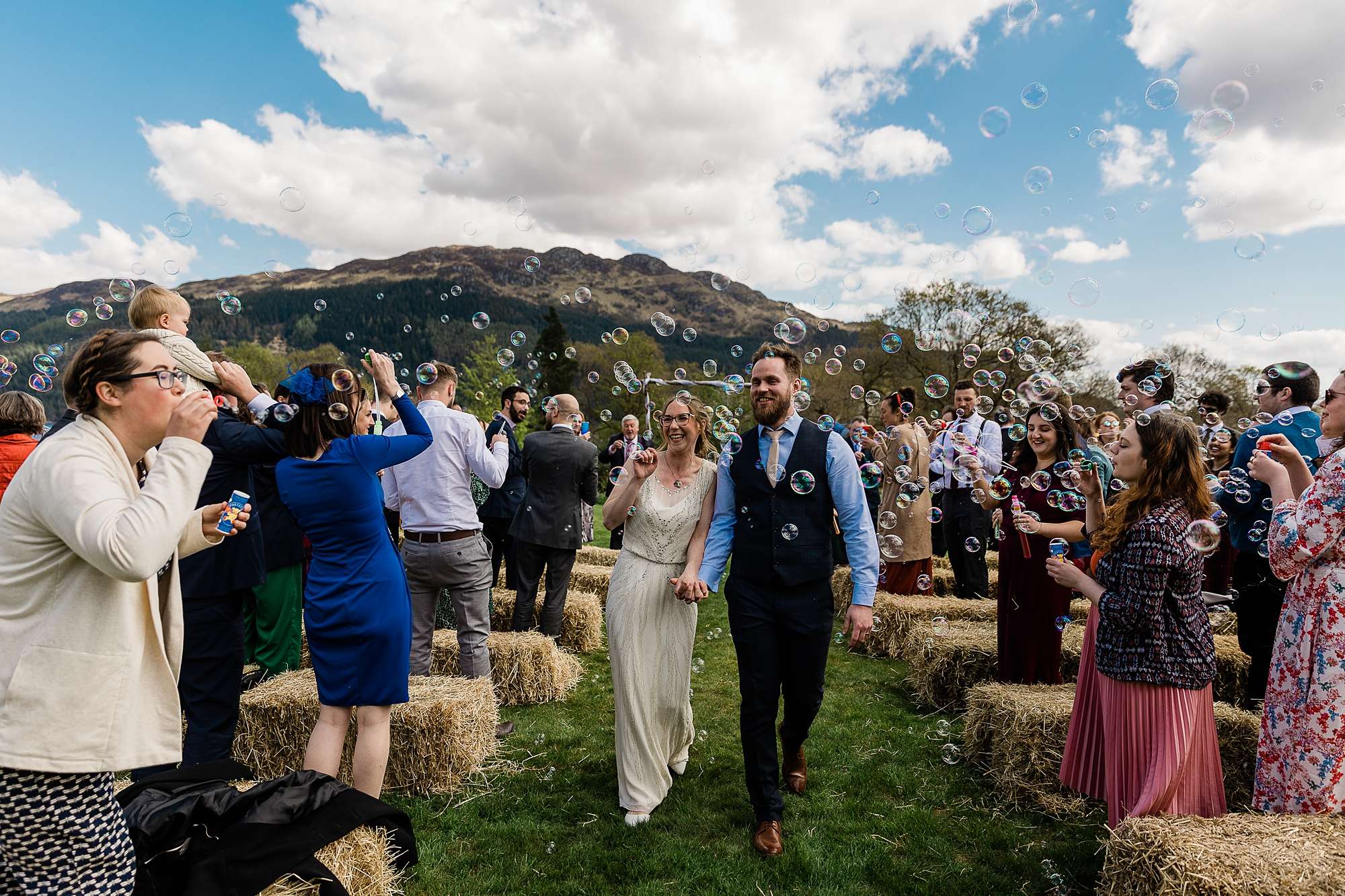 bride and groom walking through bubbles outdoor wedding ceremony at Carrick Castle estate