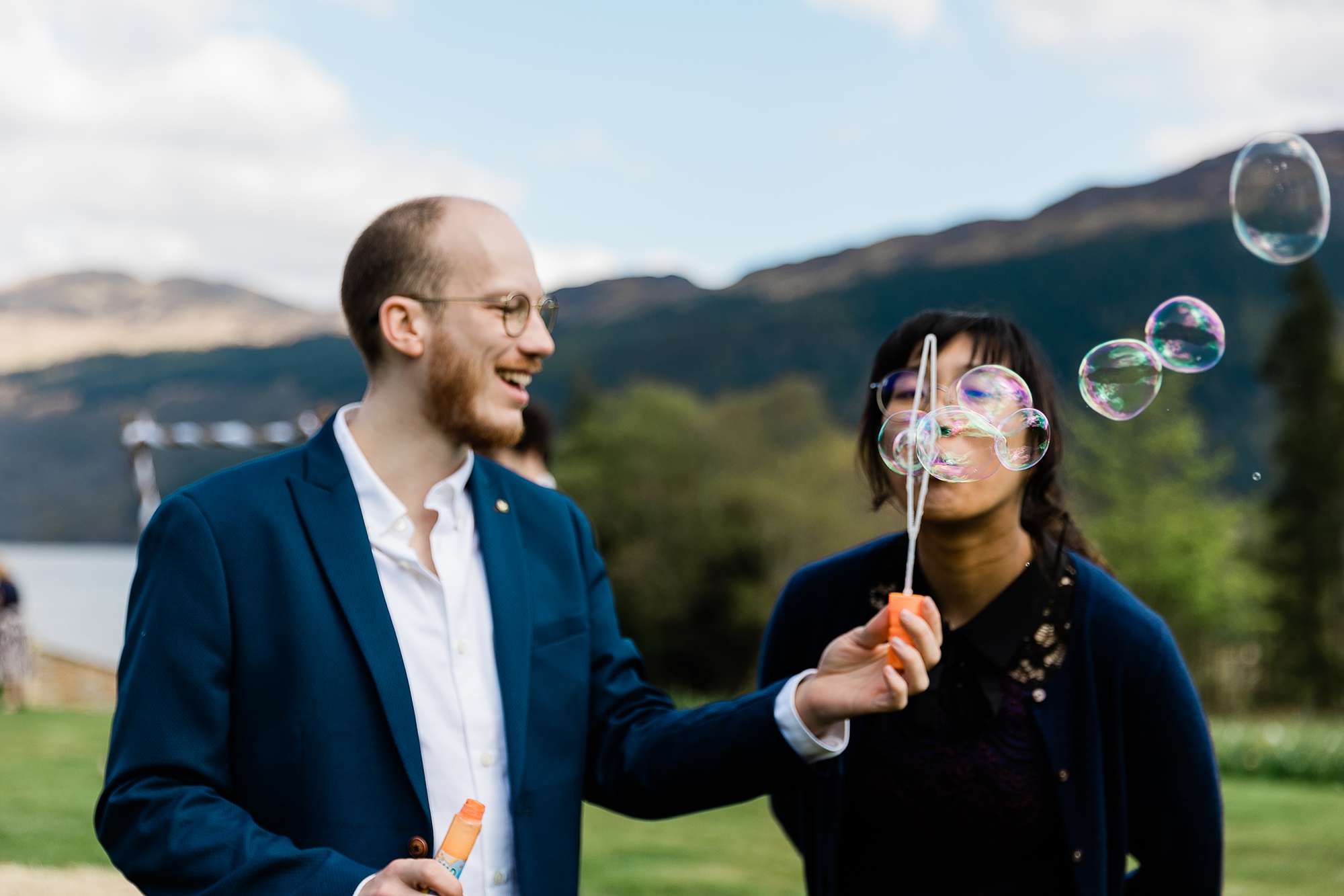guests at an outdoor wedding blowing bubbles