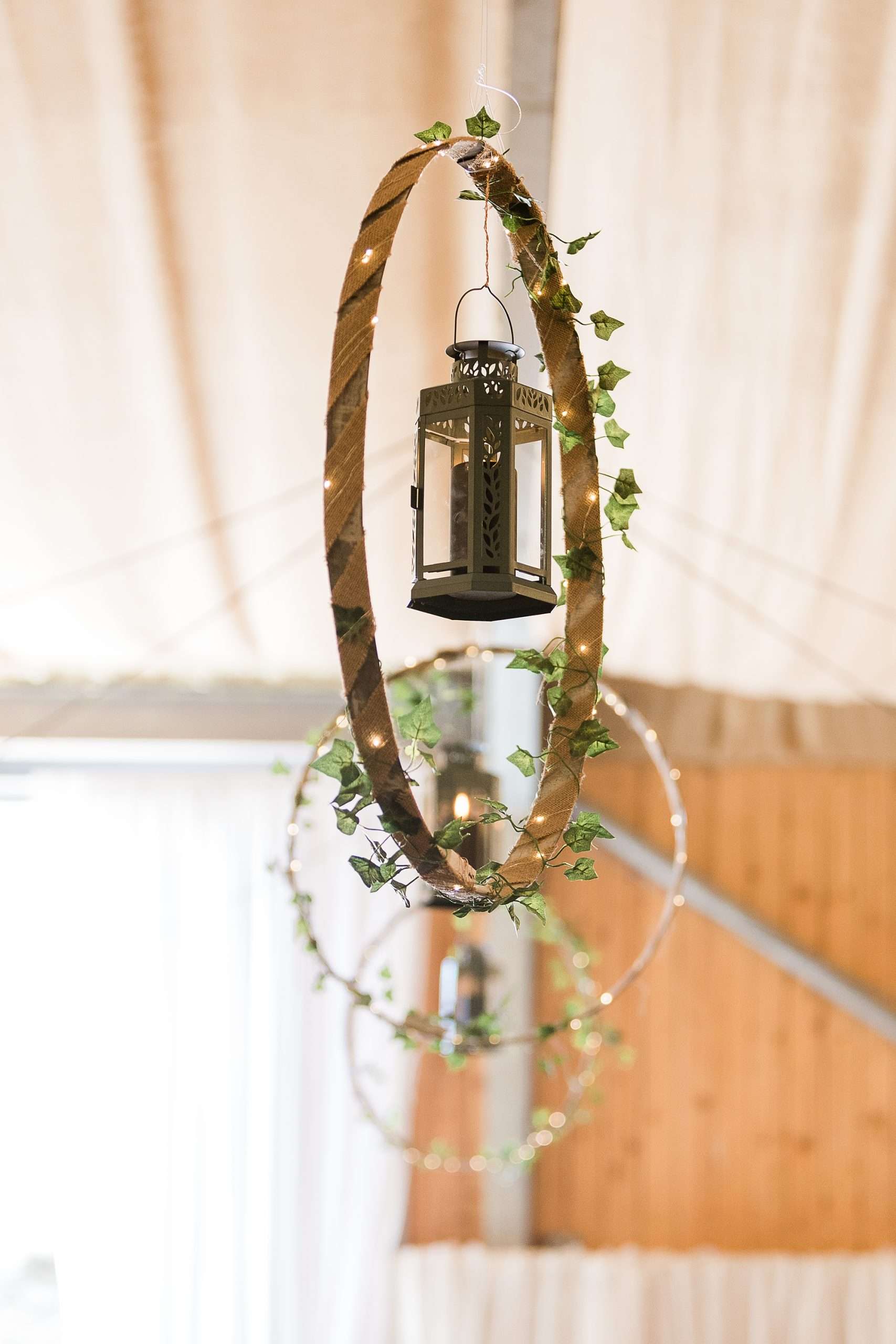 lanterns in an ivy covered wooden loop hanging from the ceiling