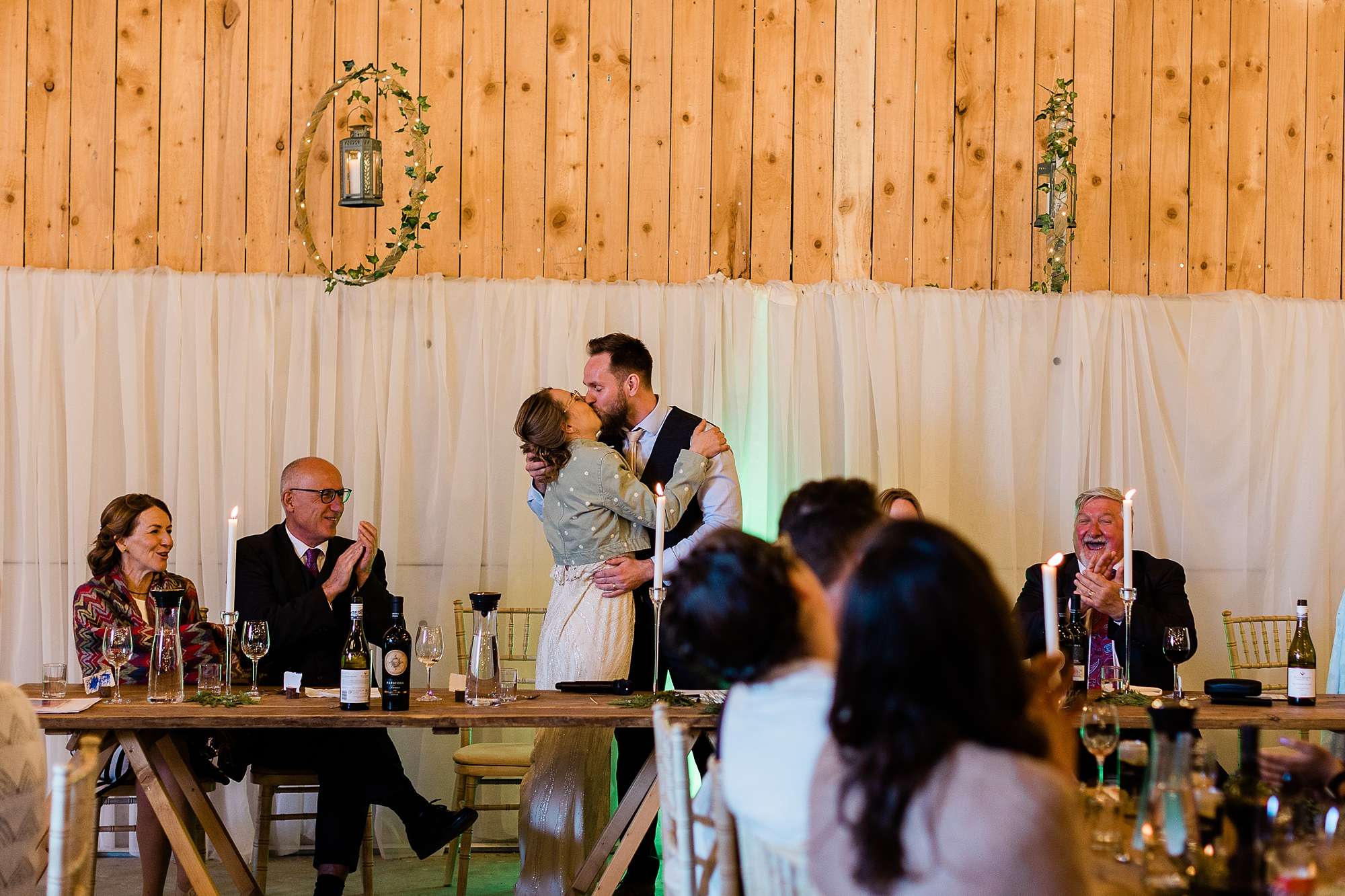 bride and groom kissing during speeches 