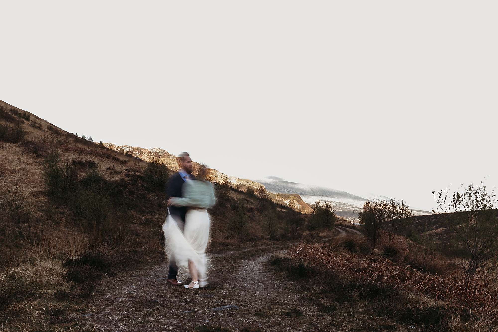 bride and groom dancing in the hills 