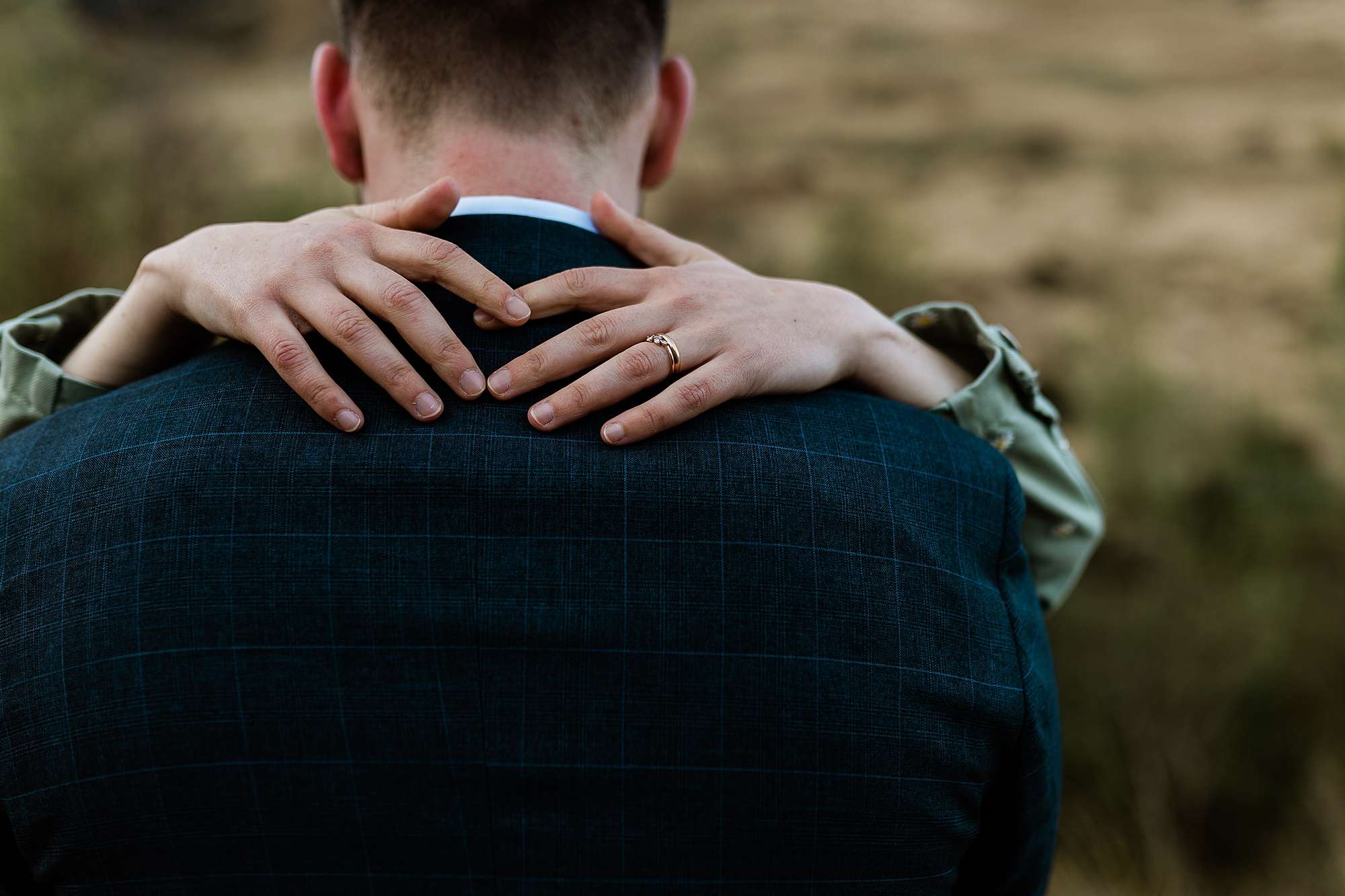 bride's hands over groom's shoulders 