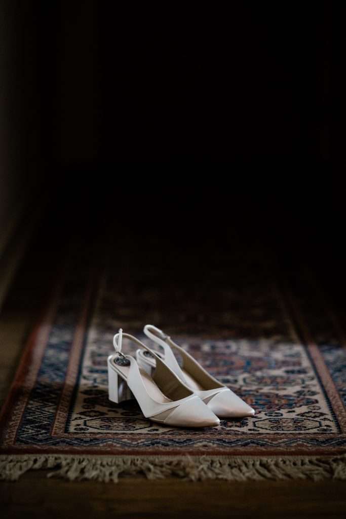 white sling back wedding shoes on a rug
