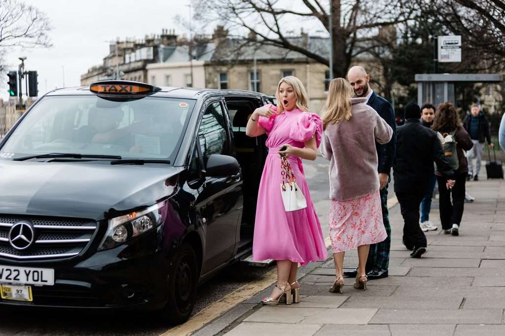 guest in pink dress arriving by taxi