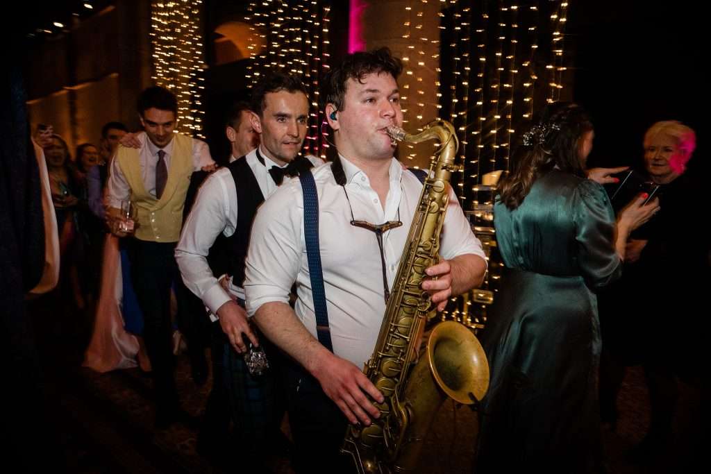 saxophonist leading a conga line 