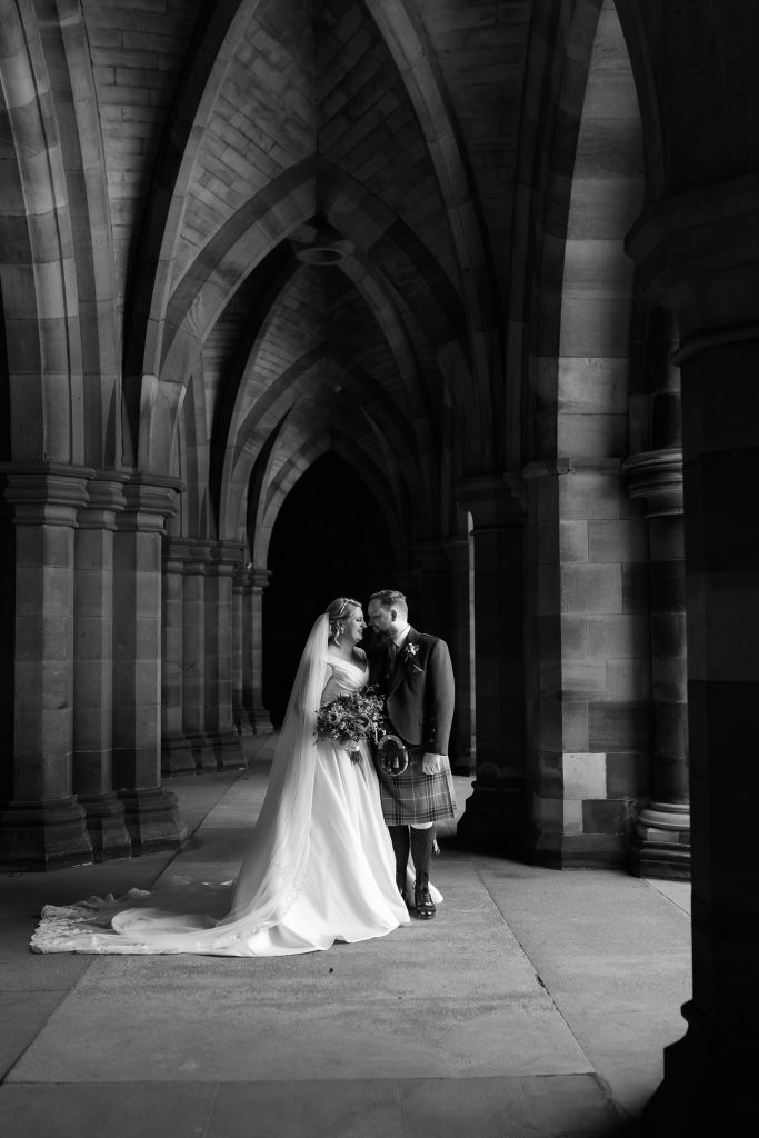 bride and groom touching noses in the cloisters at Glasgow University Chapel. 