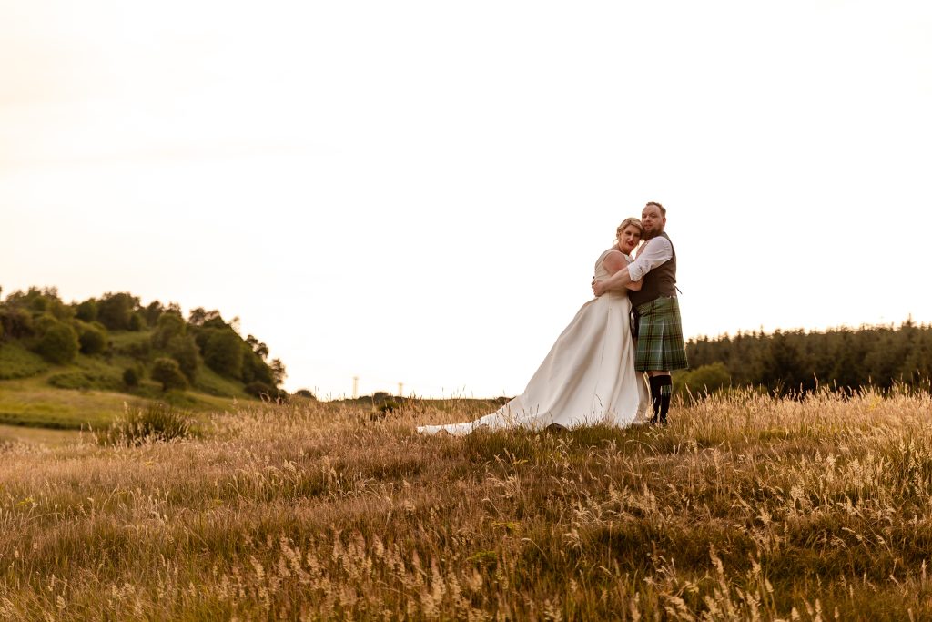 bride and groom at golden hour in a field in Scotland