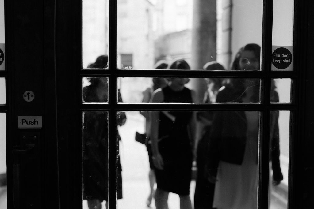 photo of bride and bridesmaids through a glass door at Leith Theatre