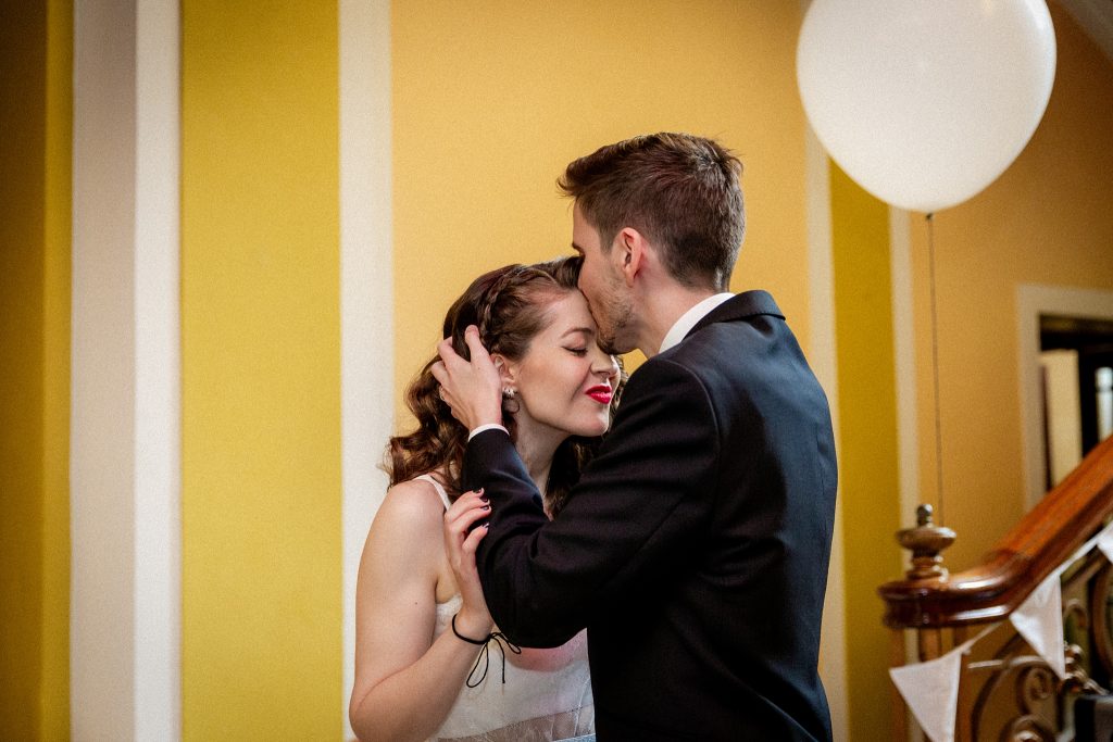 groom kissing bride's forehead wedding ceremony at Leith Theatre