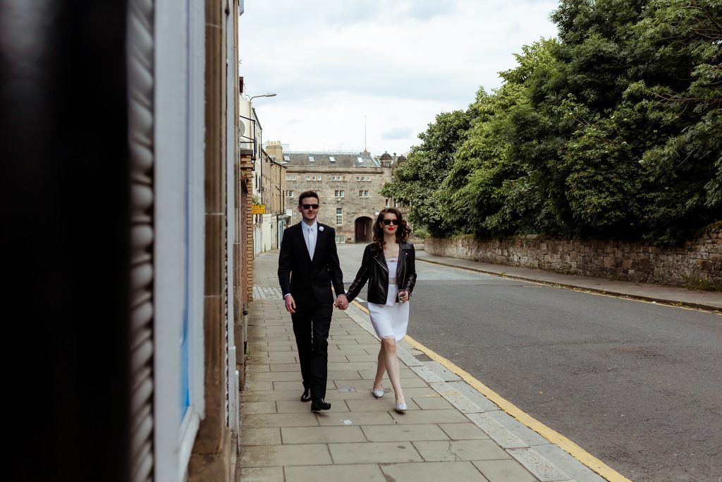 bride and groom walking up a street in Leith