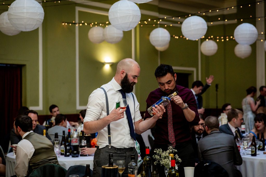 wedding guests looking at a bottle of whisky  at Thomas Morton Hall in Leith Theatre
