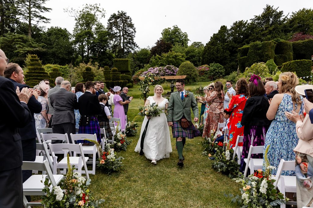 bride and groom walking down the aisle at outdoor wedding ceremony at Fingask Castle