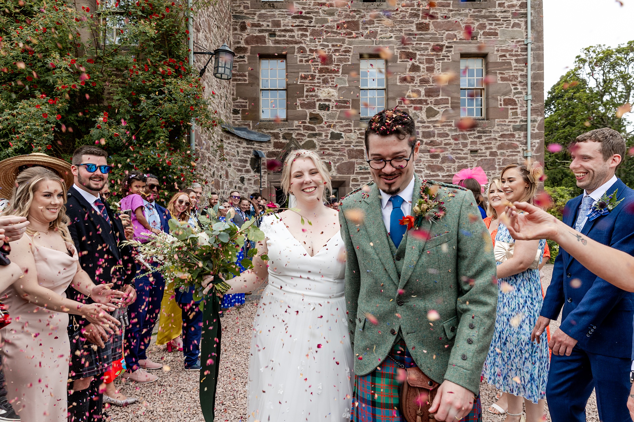 bride and groom walking through confetti throw at outdoor wedding at Fingask Castle