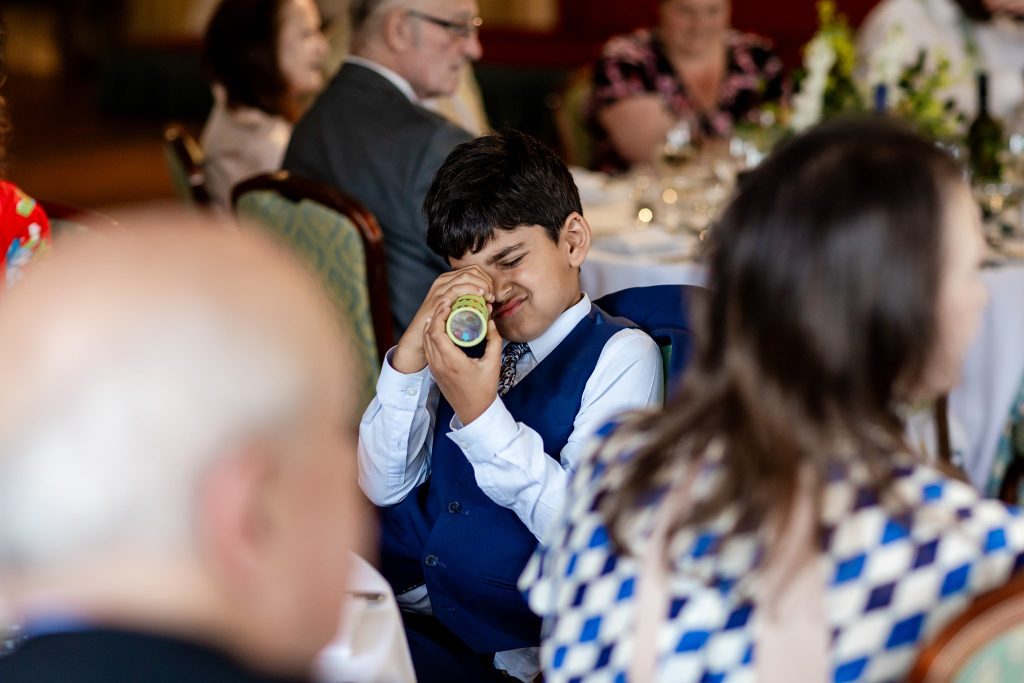 child looking through a kaleidoscope at a wedding