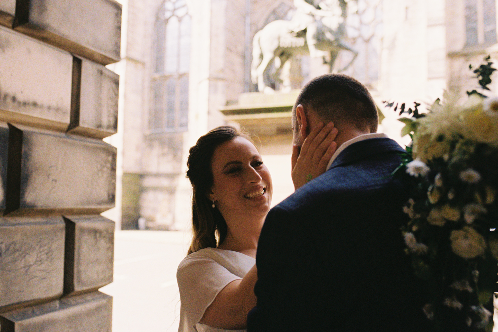 35mm analogue film photography bride stroking groom's face and smiling