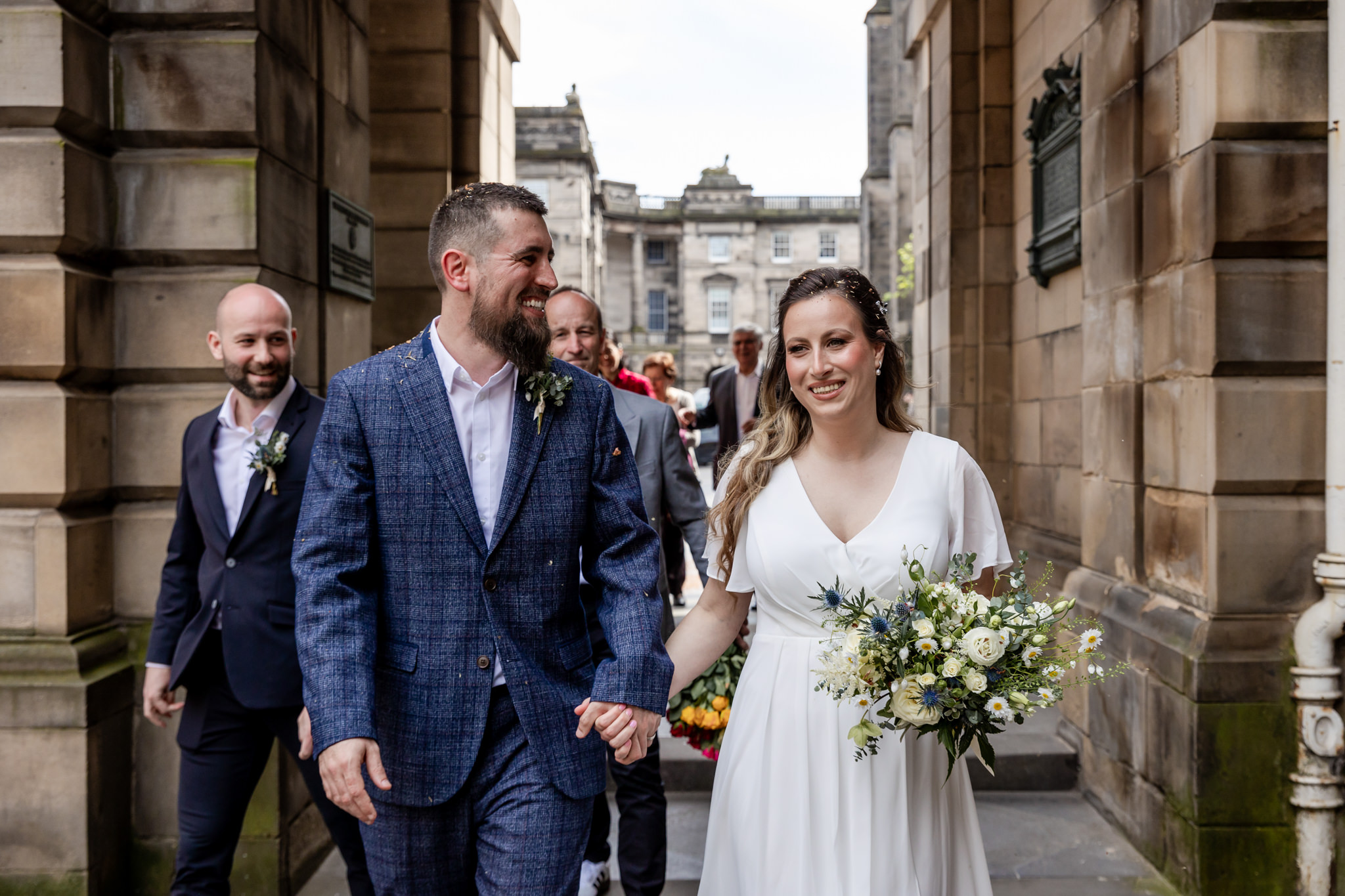 bride and groom walking next to City Chambers in Edinburgh