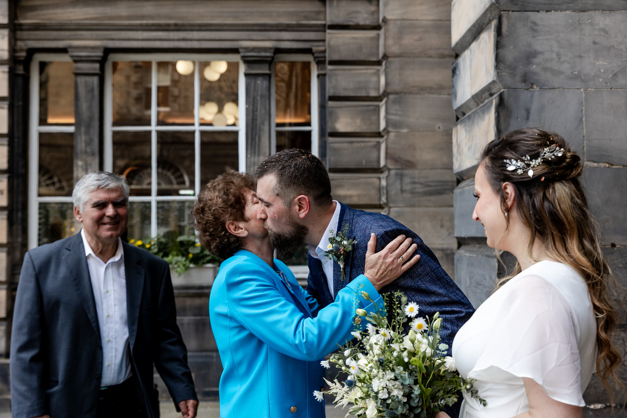 guests kissing groom after wedding ceremony