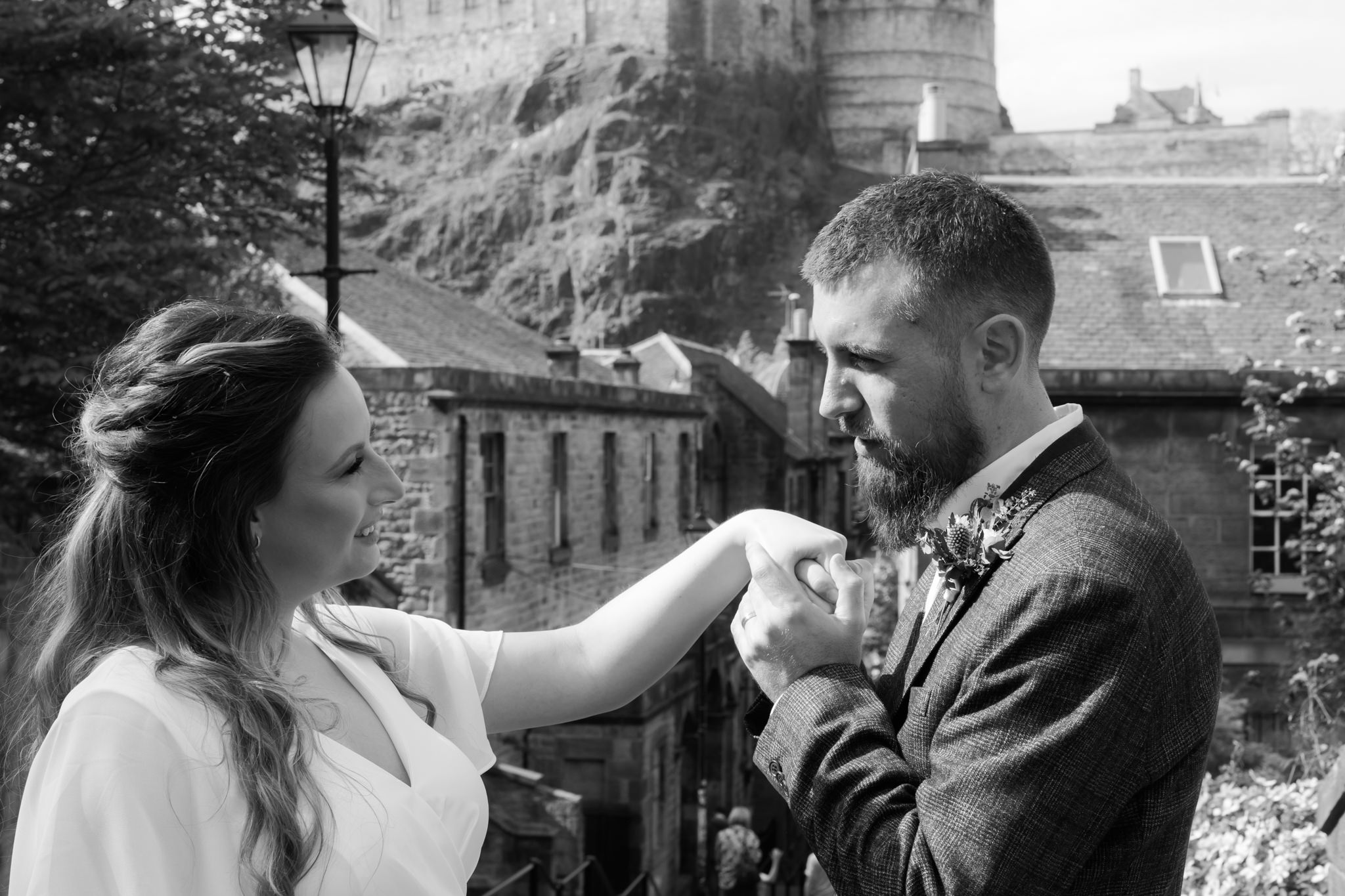bride and groom embracing on the Vennel in Edinburgh with Edinburgh Castle in the background