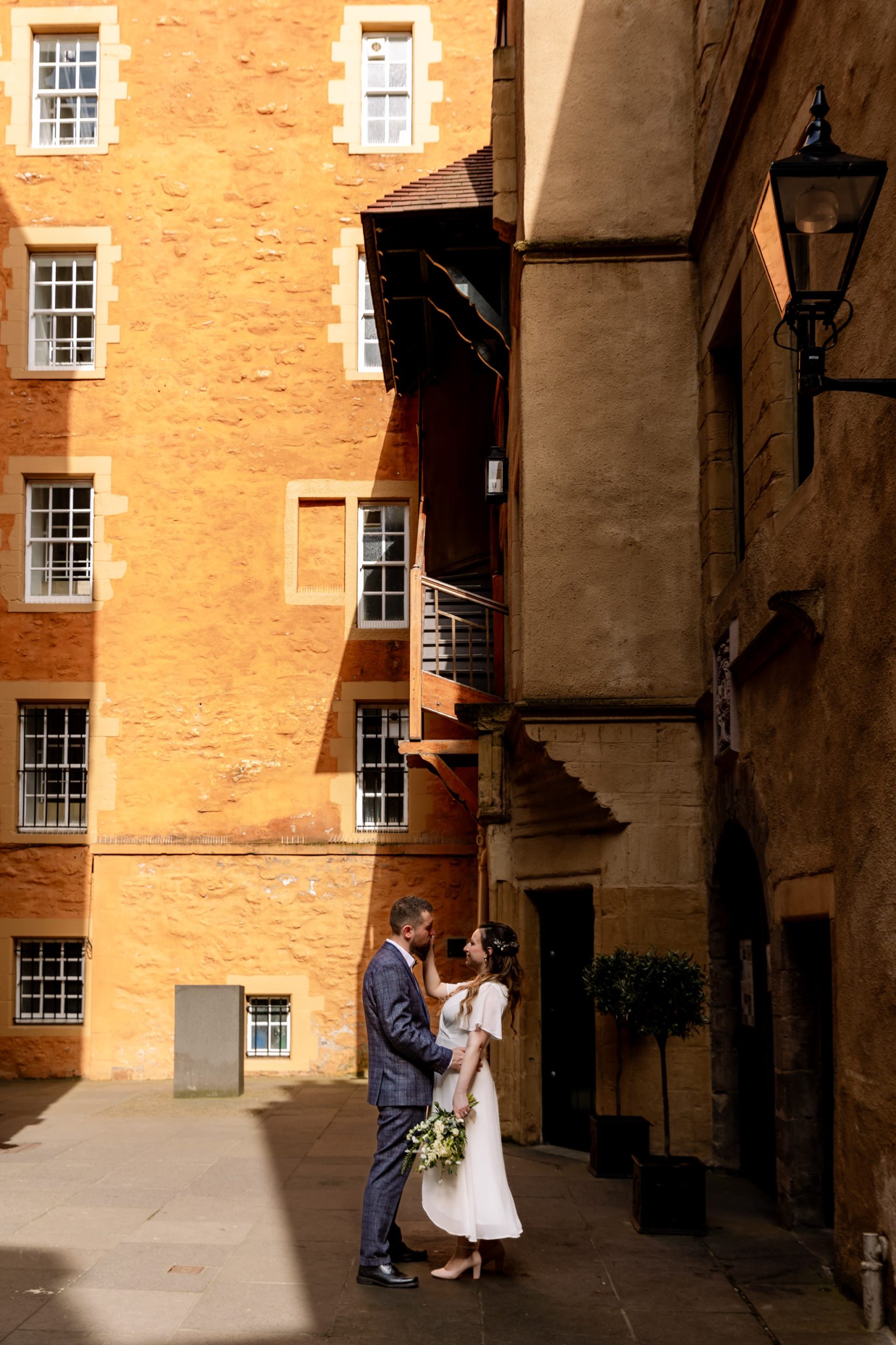 bride and groom embracing in Riddles Court, off Royal Mile in Edinburgh