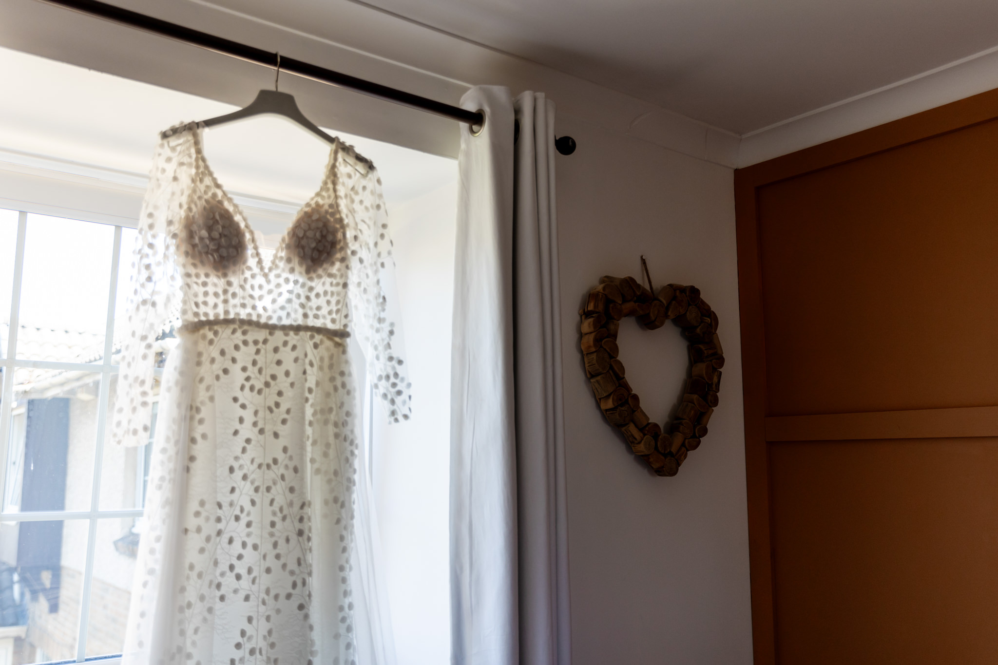 wedding dress hanging in bedroom window