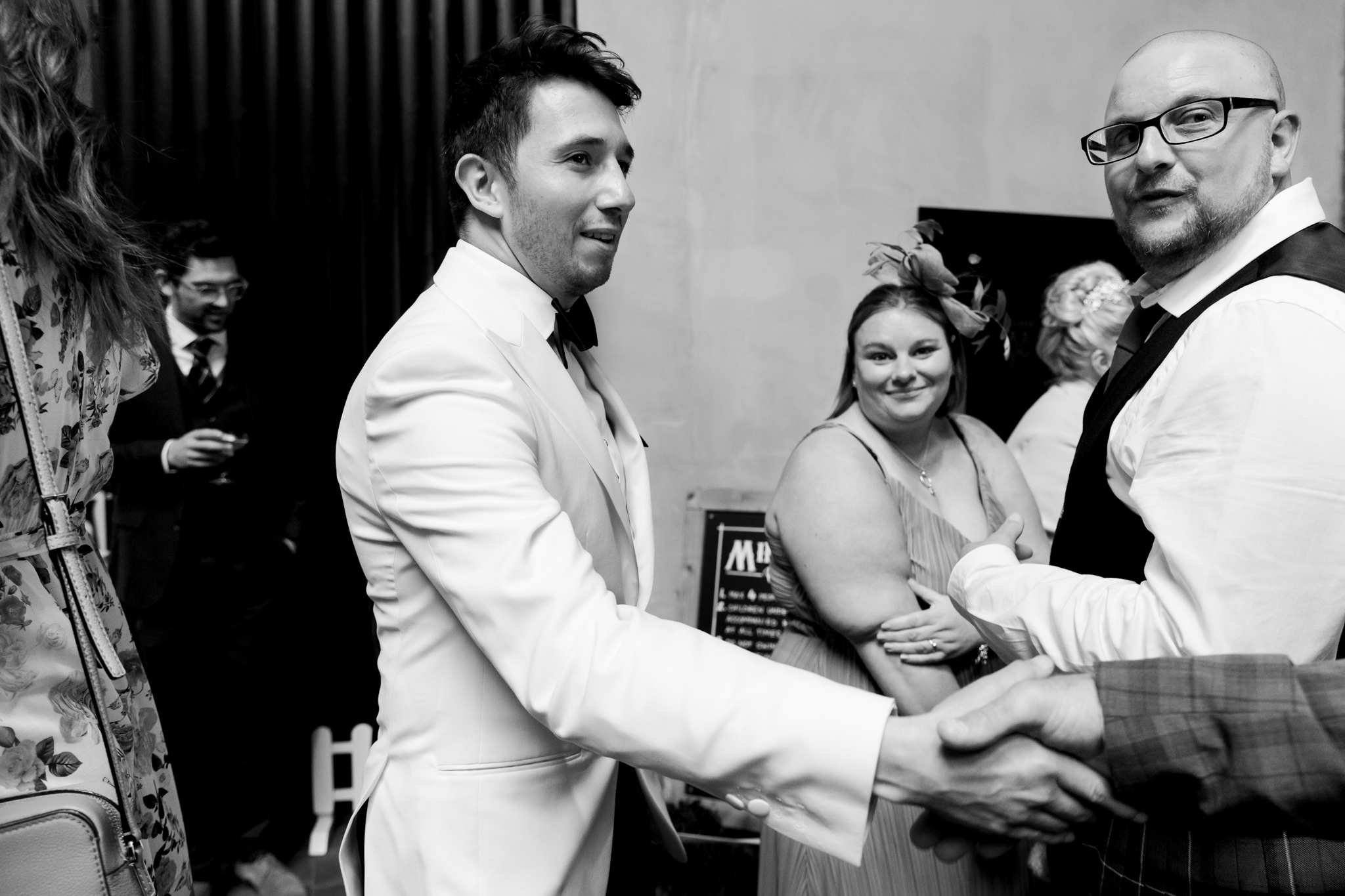 groom shaking hands with guests
