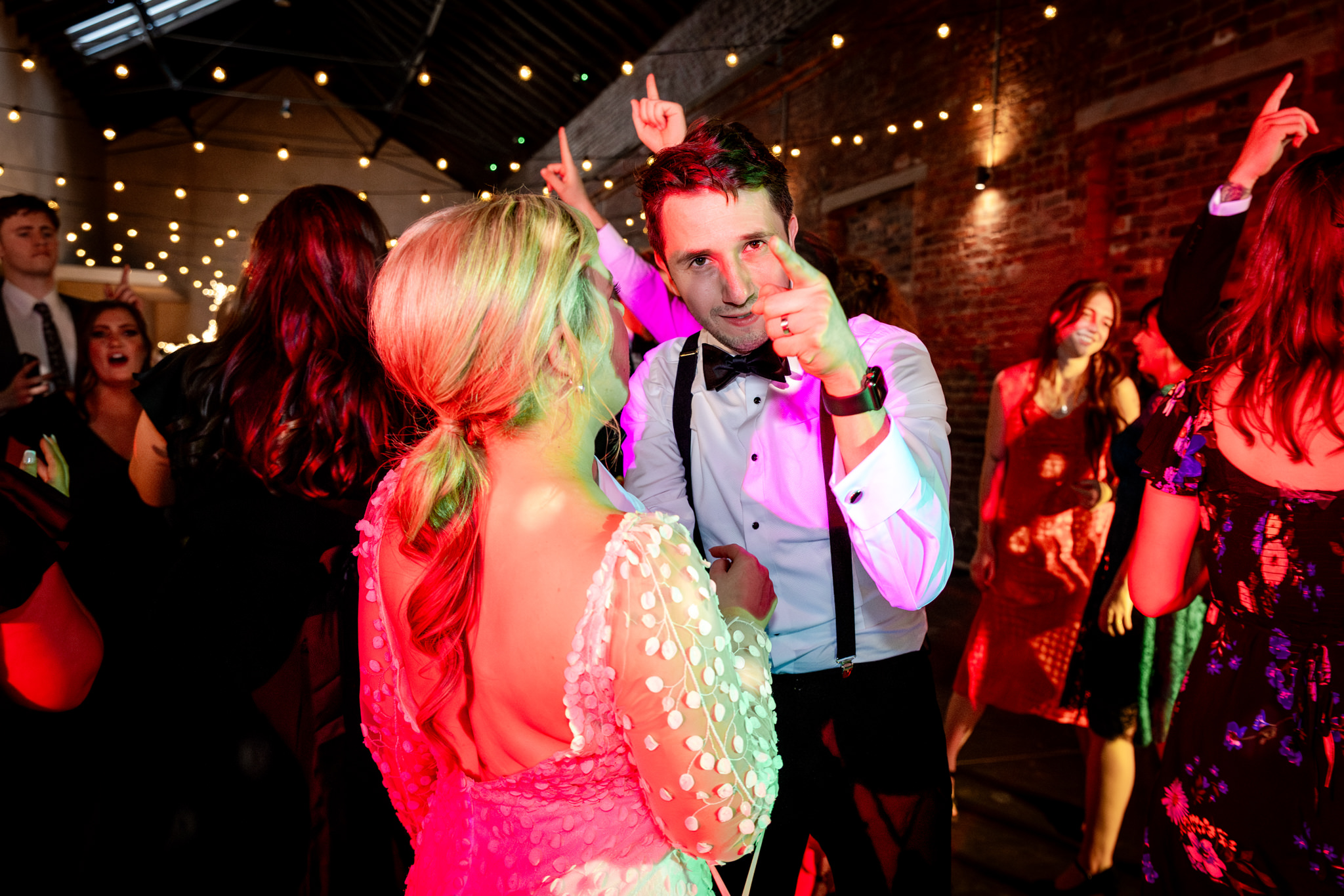 groom pointing his finger on the dancefloor at the camera