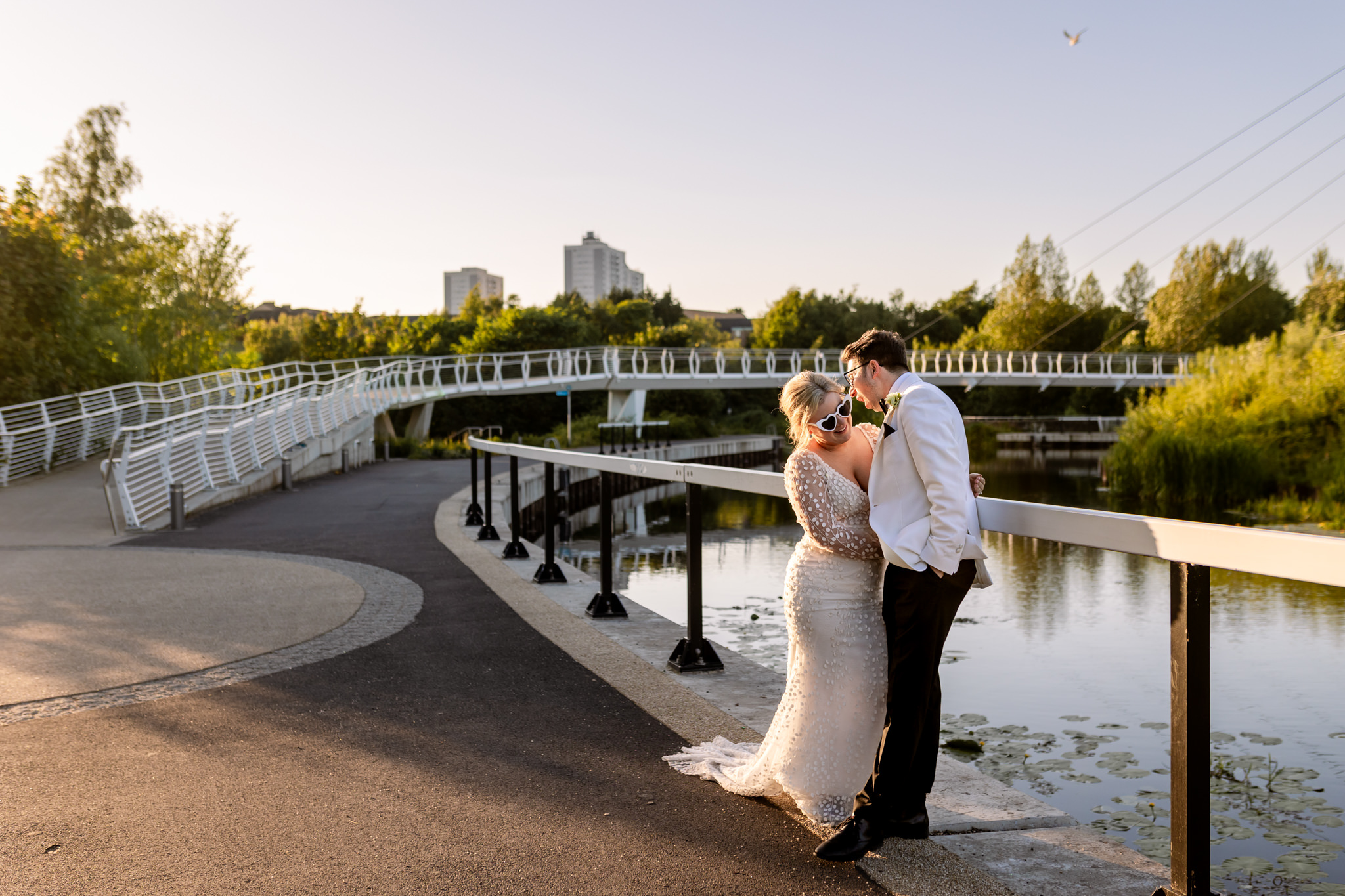 bride and groom in sunglasses standing next to the canal in Glasgow