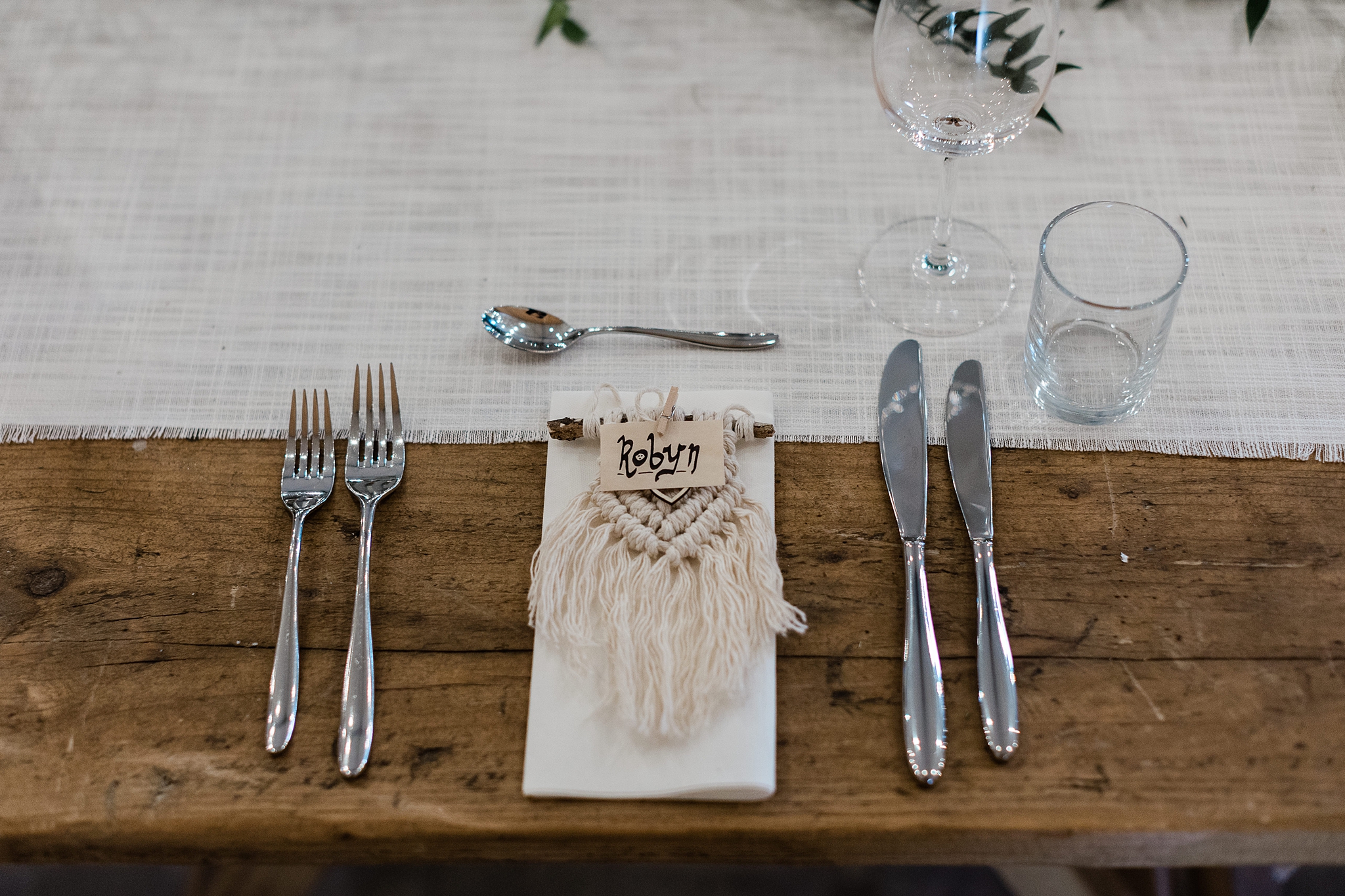 macrame place setting on a wooden table with a linen runner at a celtic folklore theme wedding in Scotland