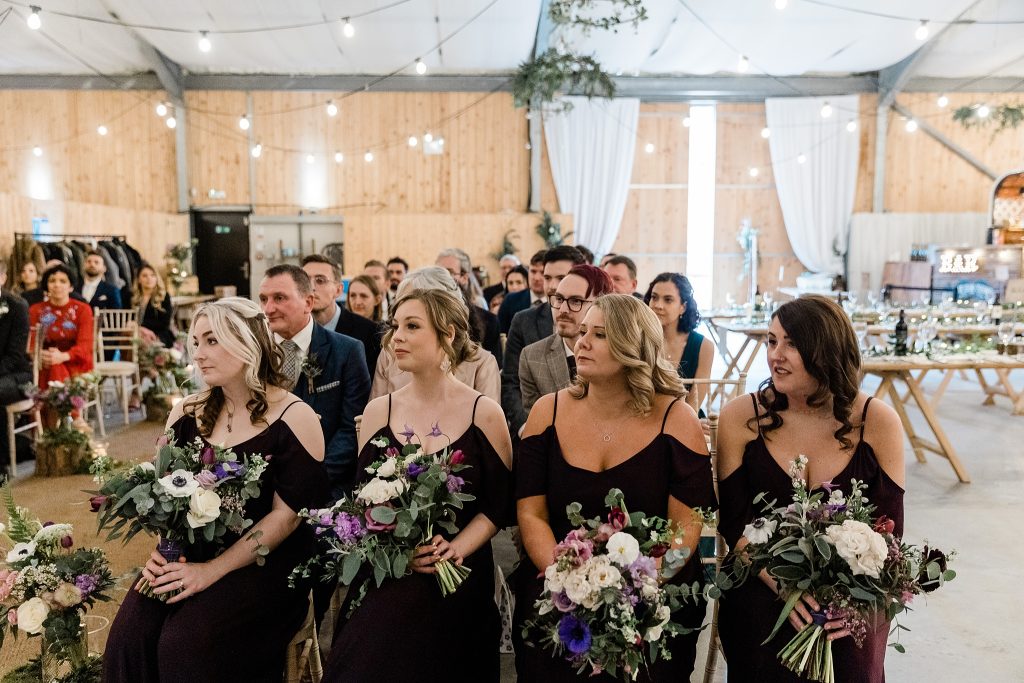 guests watching a wedding ceremony in the barn at Carrick Castle Estate. 