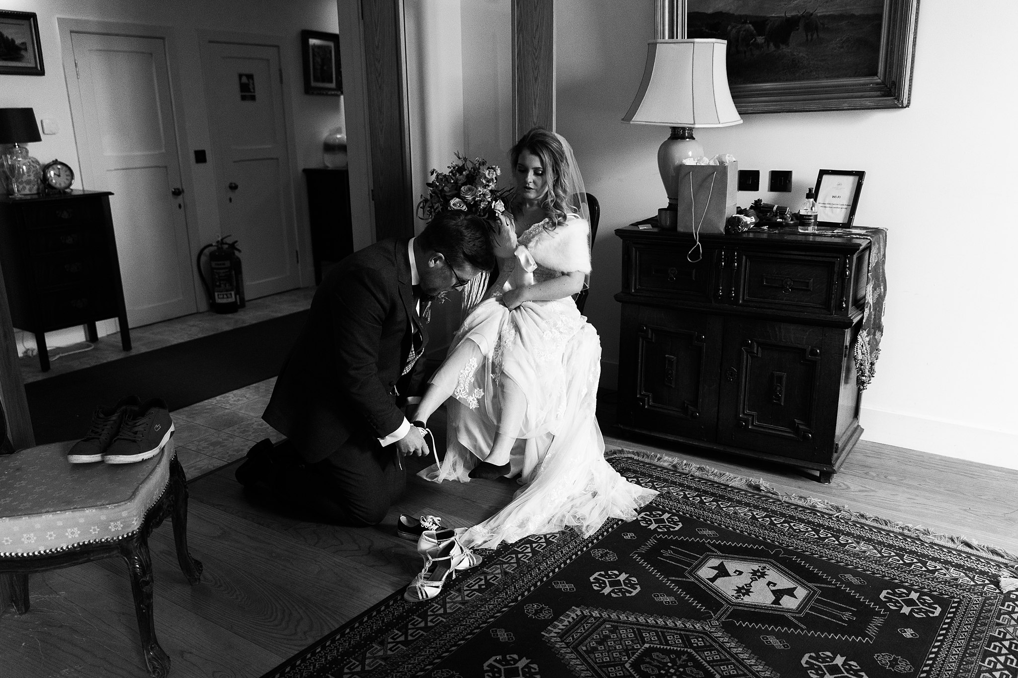 groom helping bride change footwear
