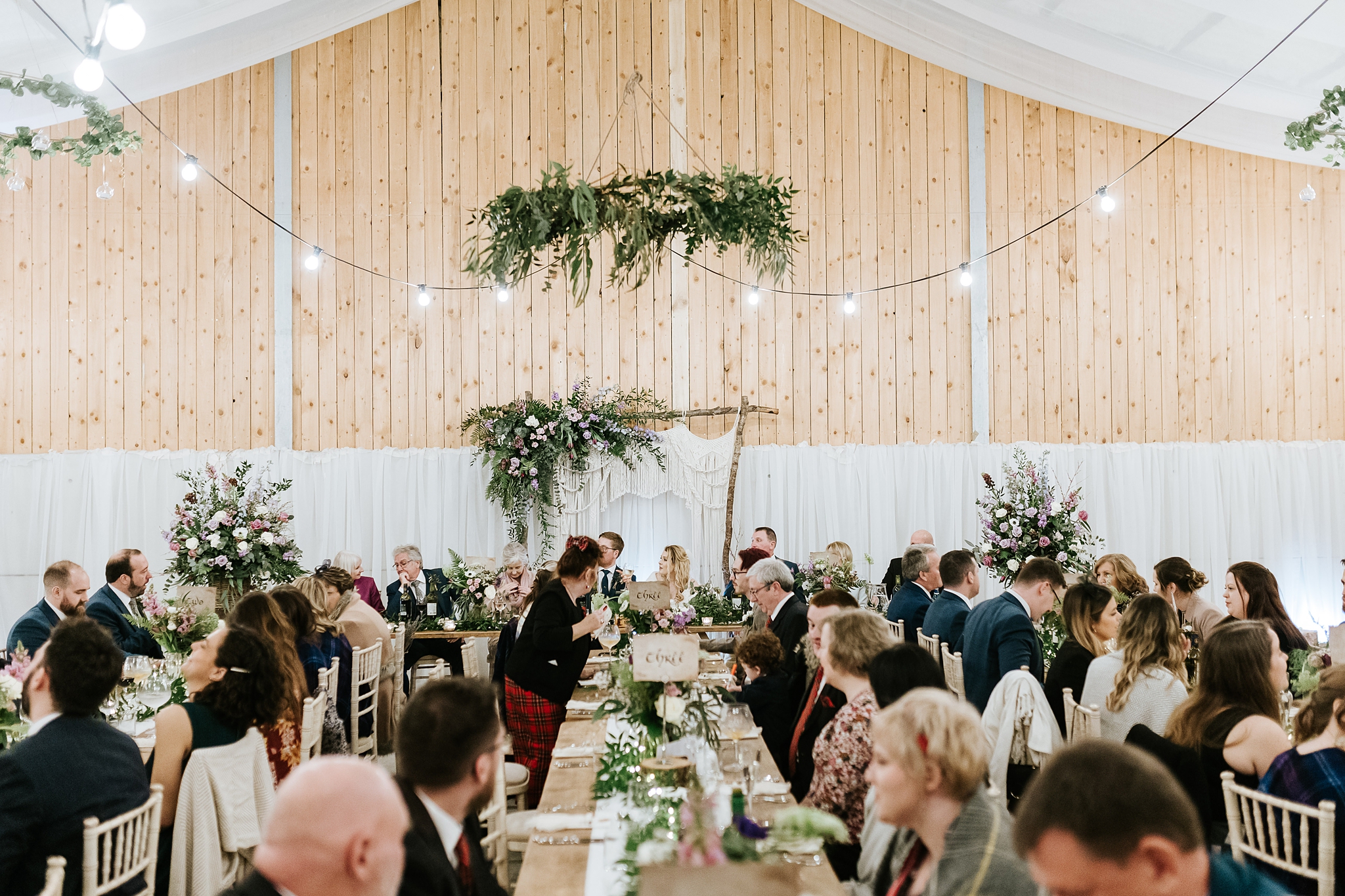 tables arrangement with floral overhanging displays and lighting at a barn celtic folklore theme wedding at Carrick Castle Estate in Scotland