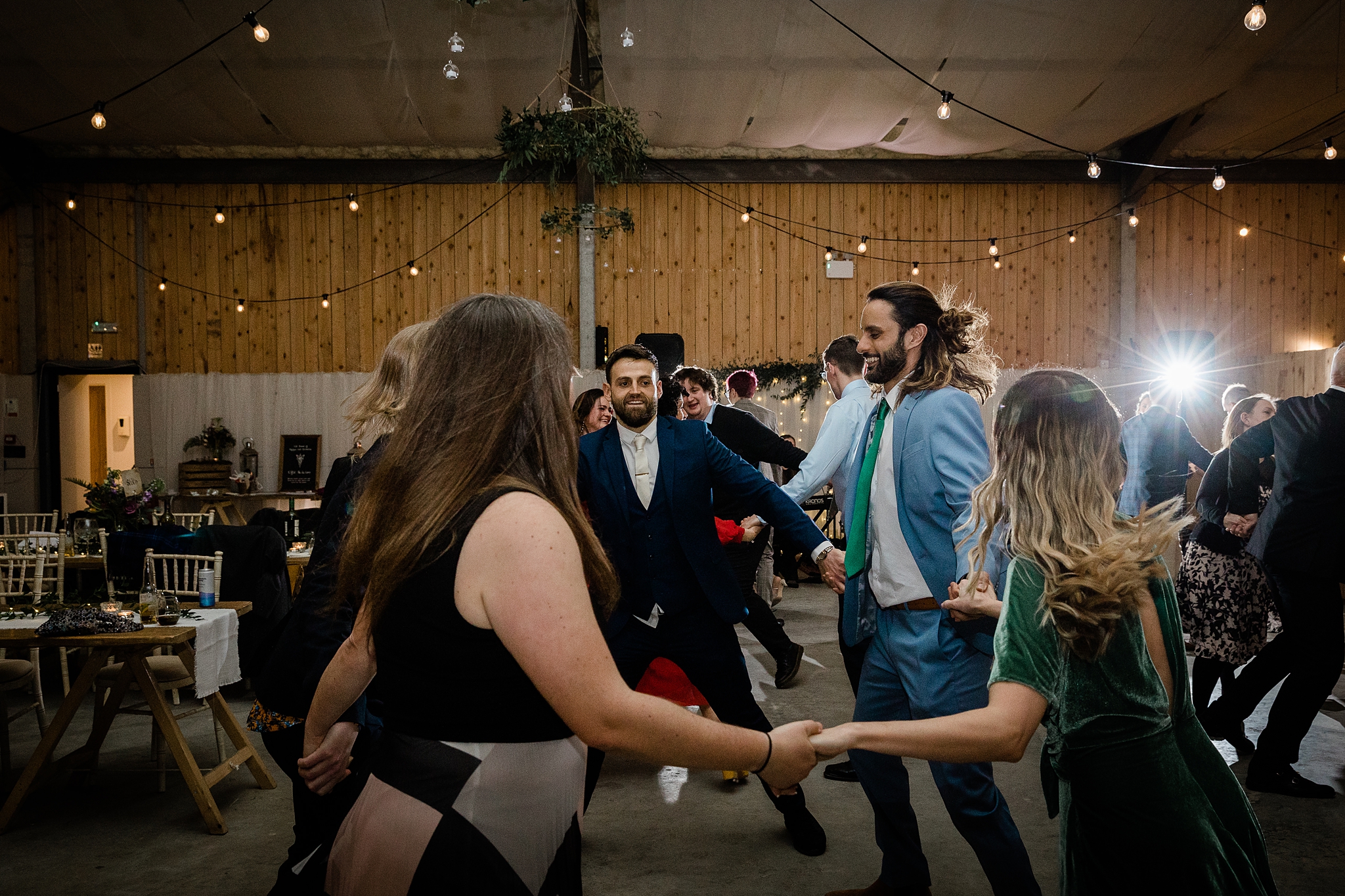 wedding guests ceilidh dancing at a barn wedding at Carrick Castle Estate in Scotland