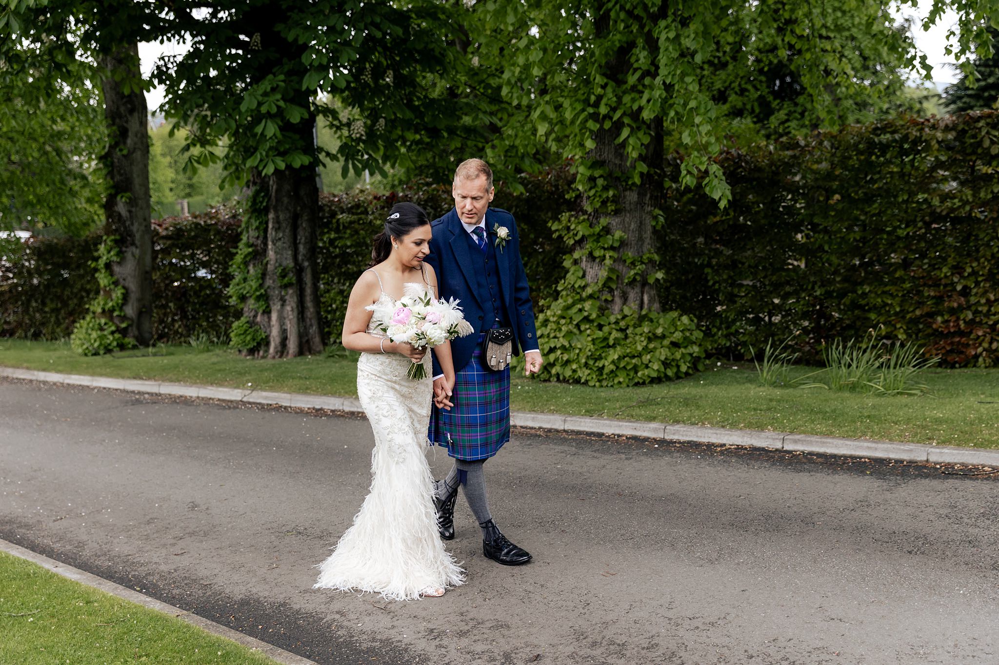 Bride and groom walking along driveway Boclair House wedding