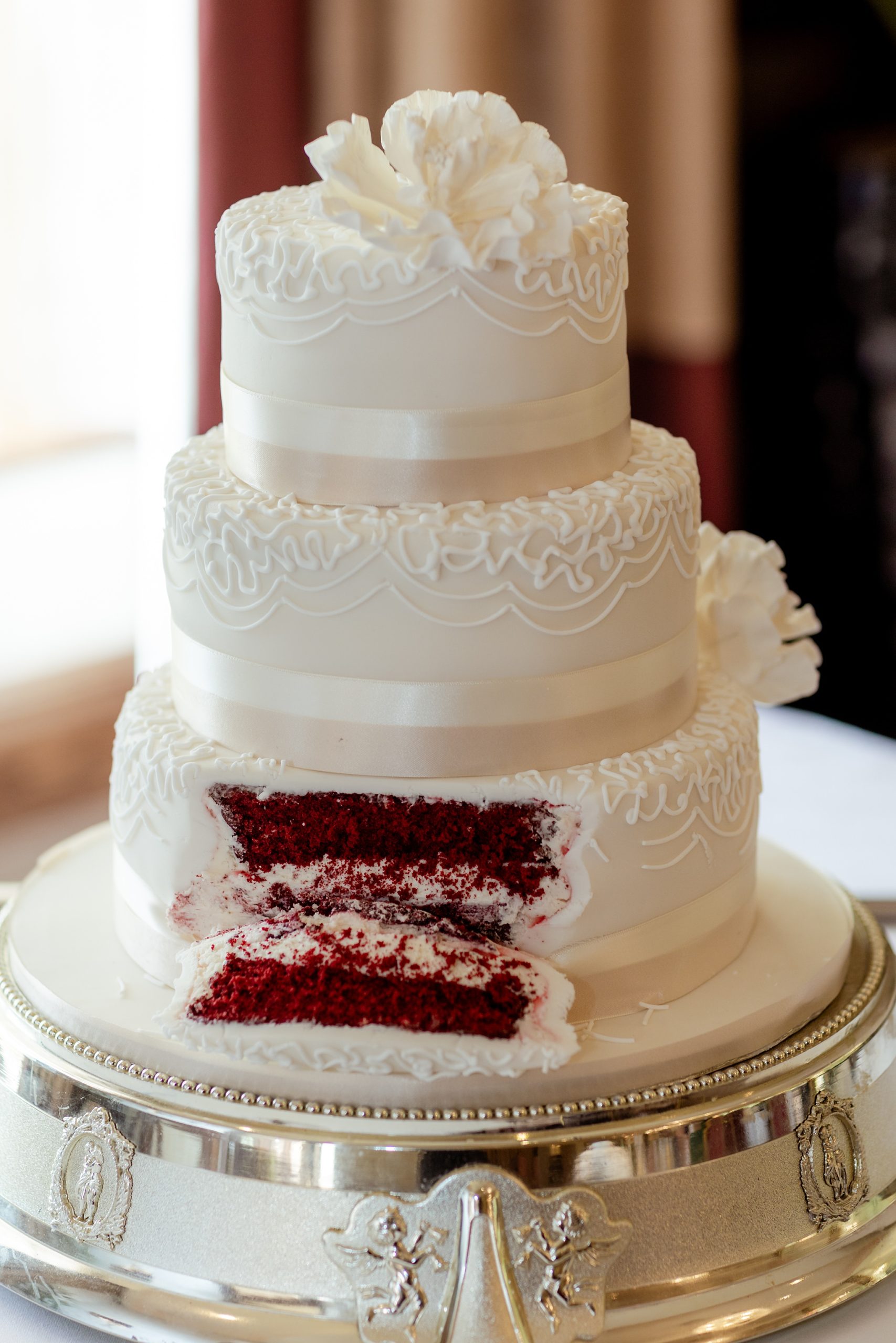 slice of white wedding cake showing red velvet cake