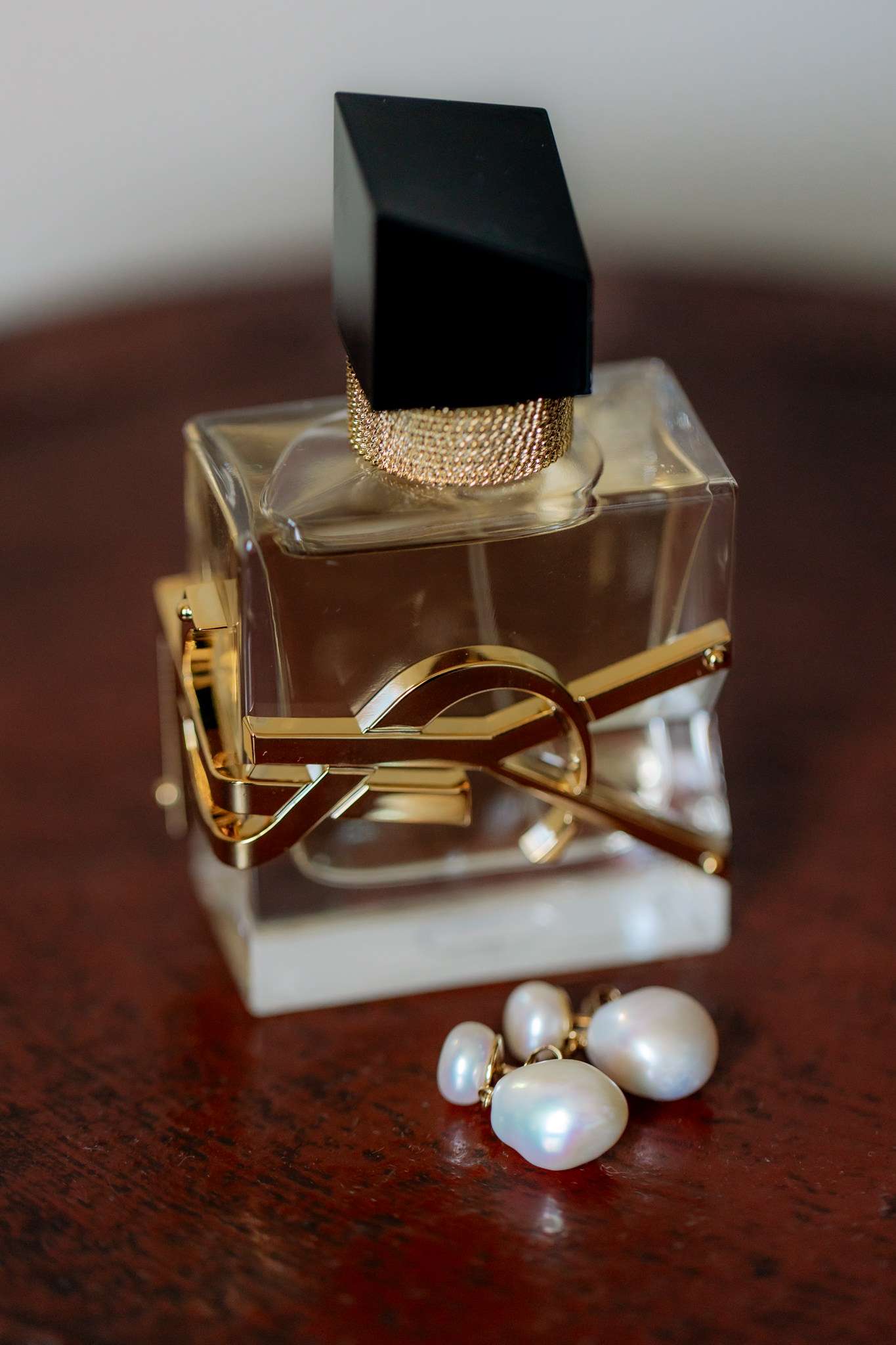YSL perfume bottle and pearl earrings