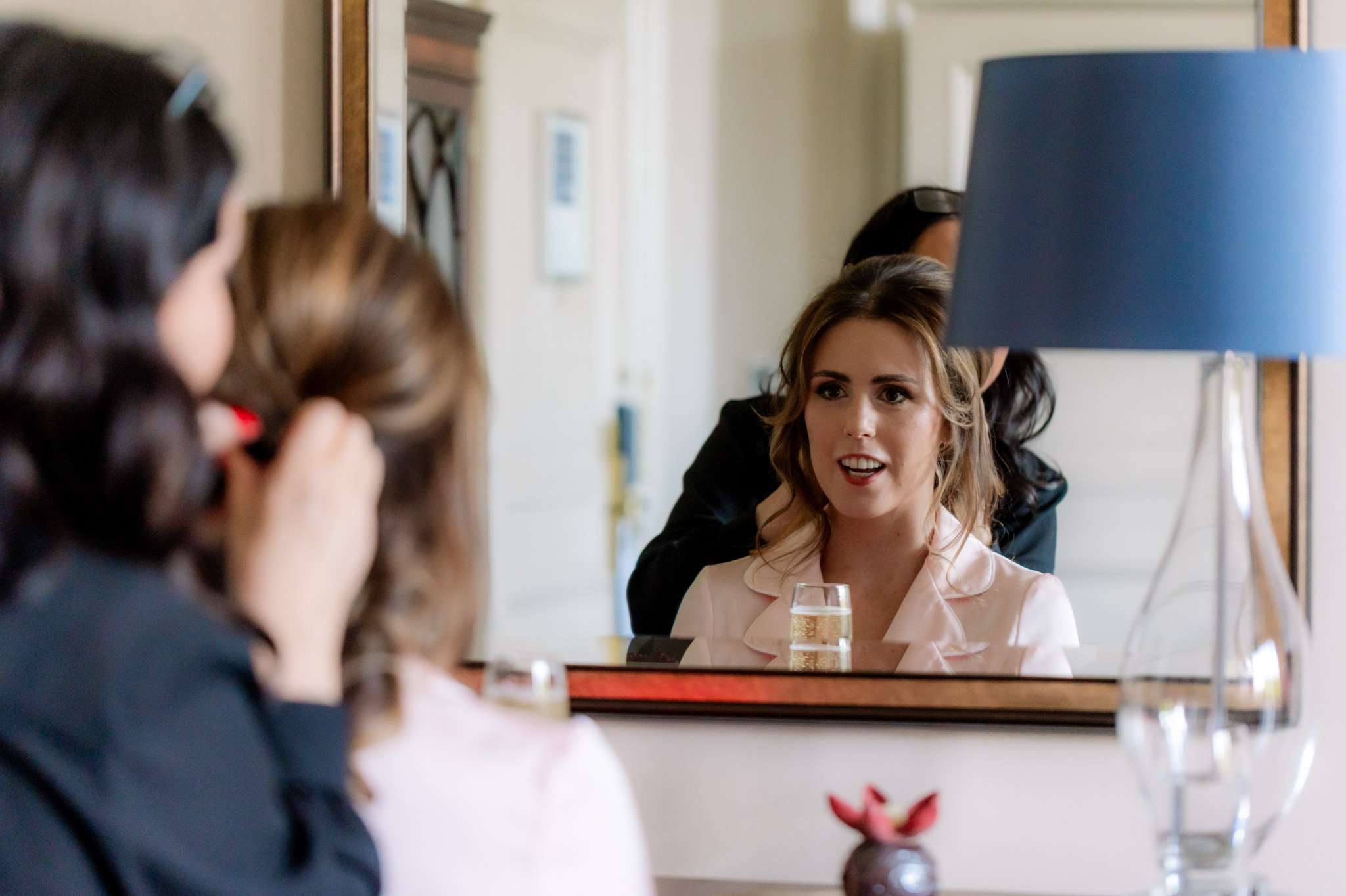 bride checking her hair in a mirror with hair stylist