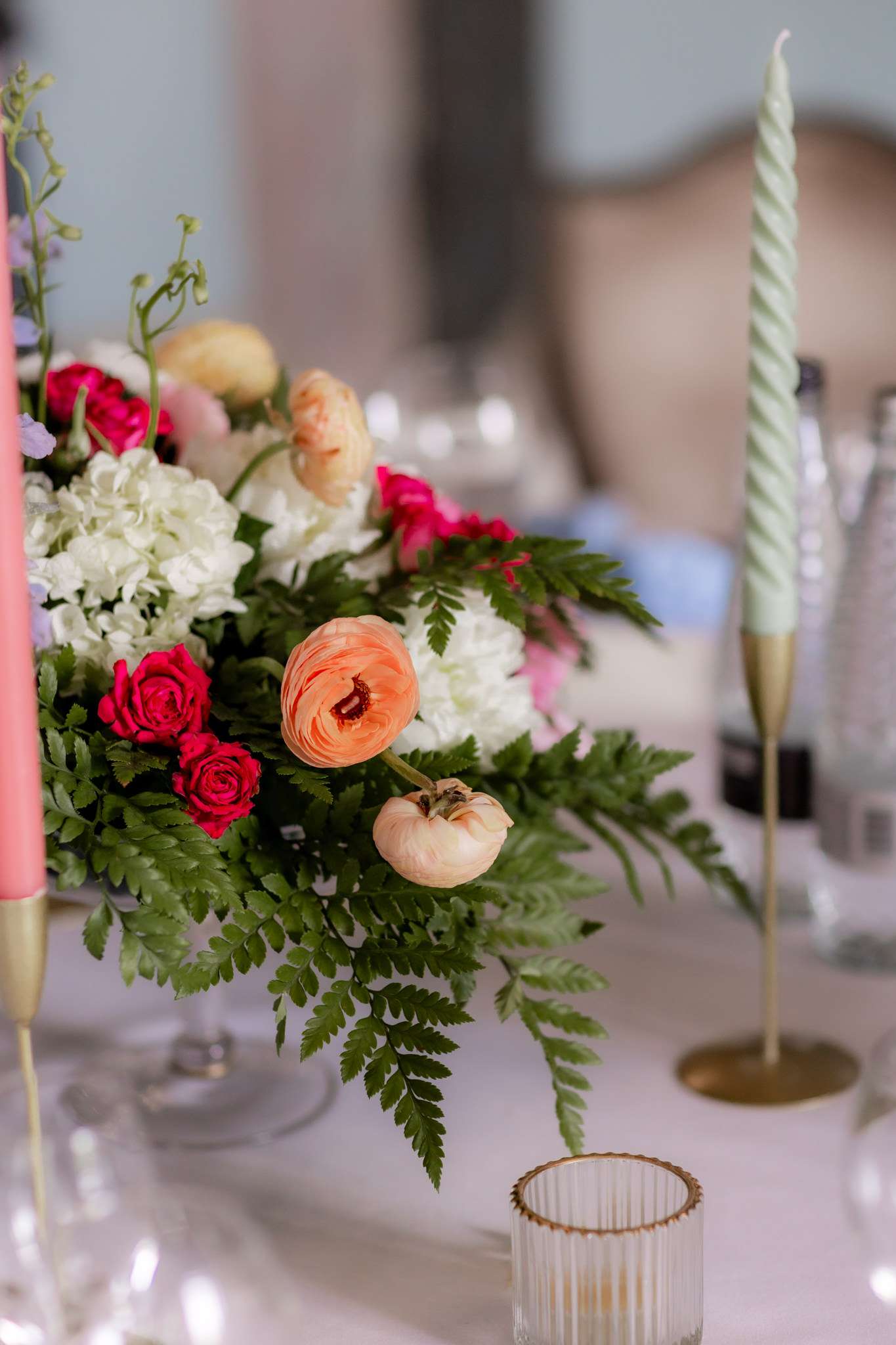 pale pink and green candles, and pink and white flowers on a wedding table 