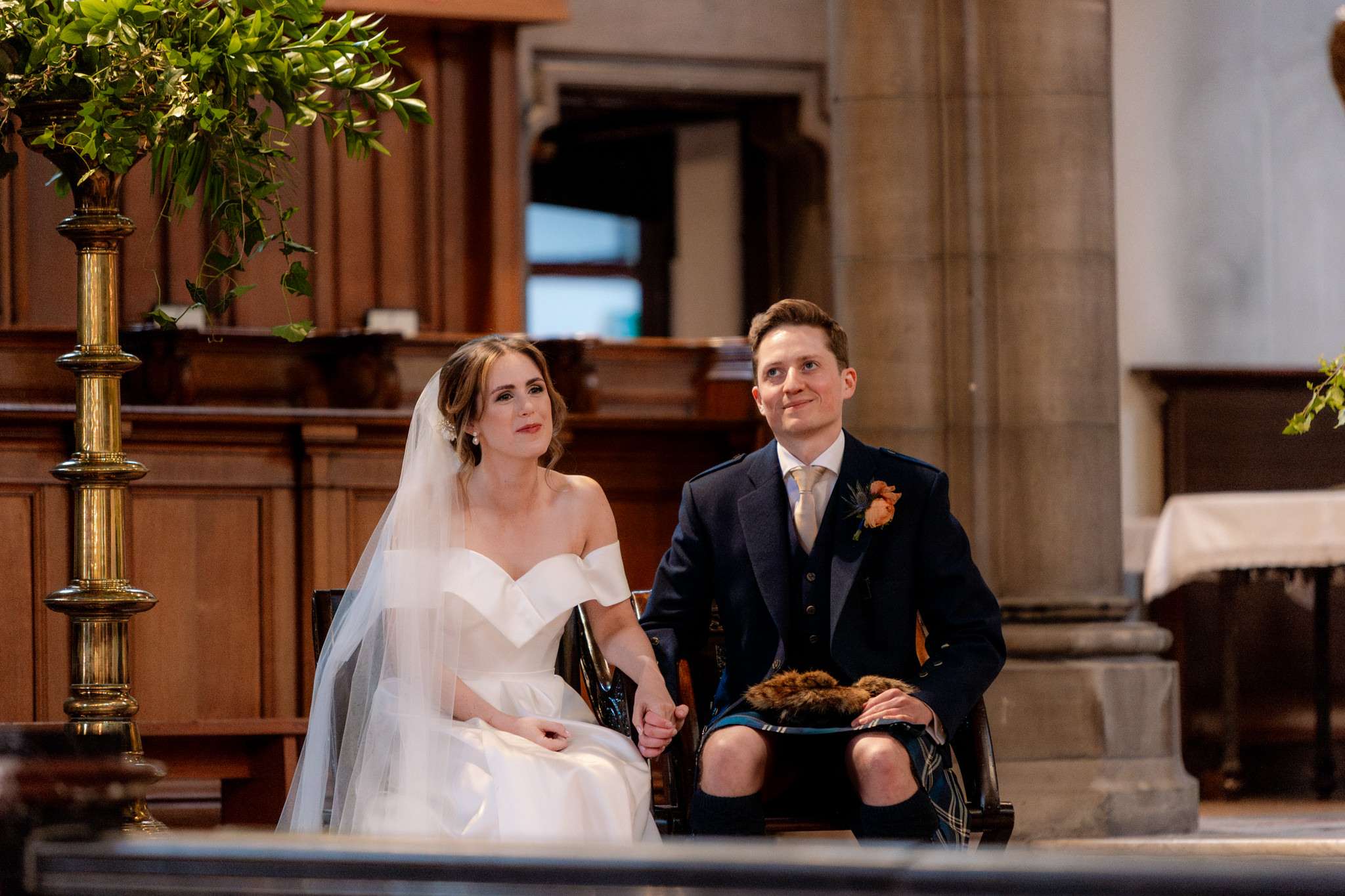 bride and groom sitting during a wedding ceremony at  St Mary's Cathedral Edinburgh 
