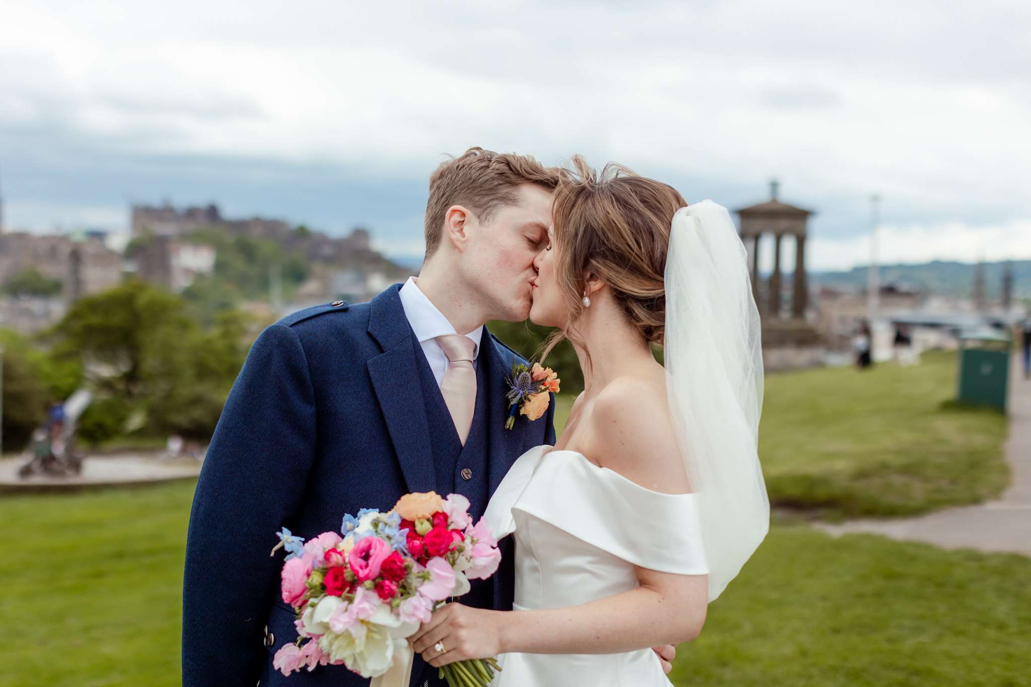 bride and groom kissing on top of Carlton Hill, Edinburgh 