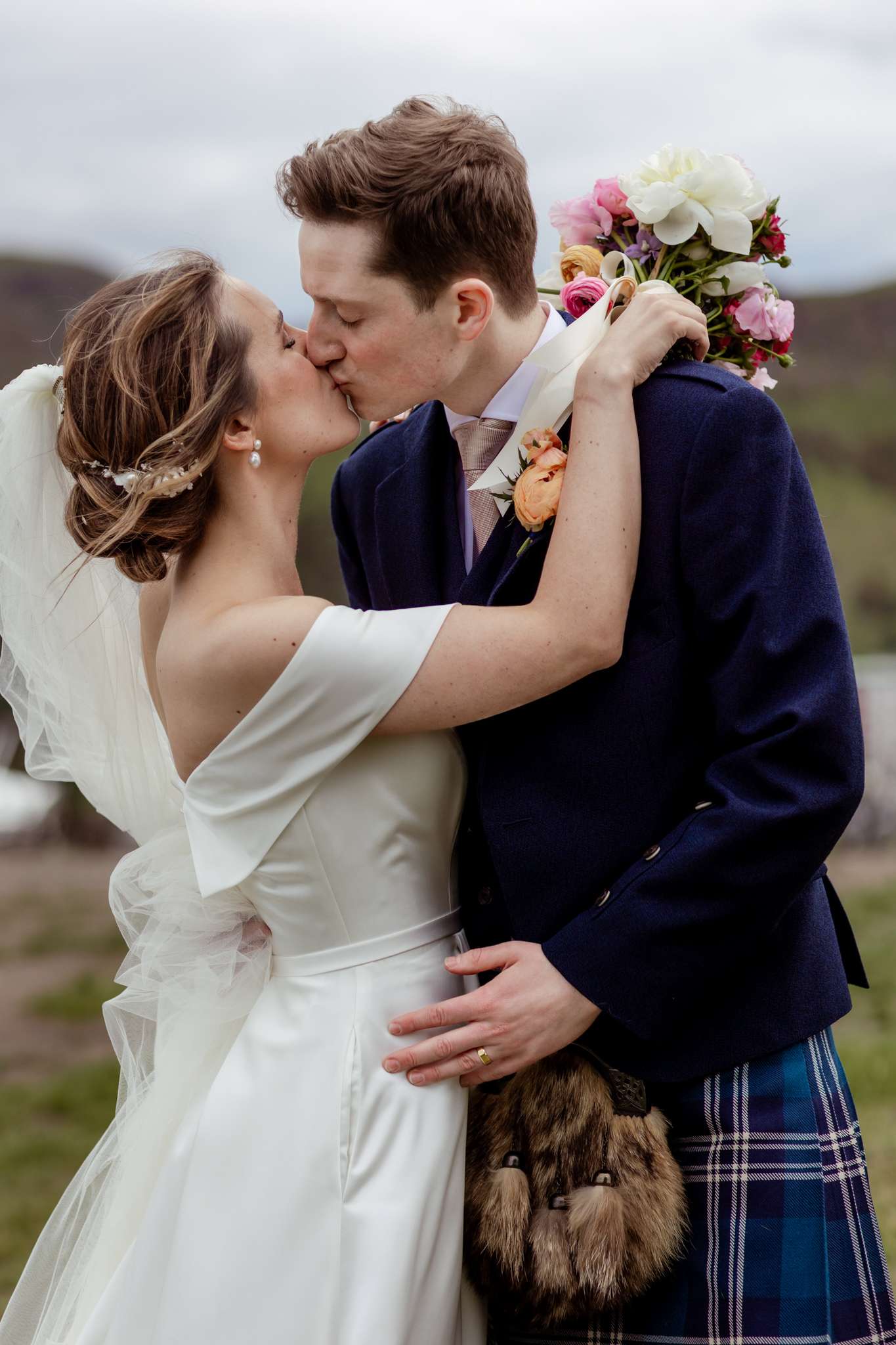 bride and groom kissing on top of Carlton Hill, Edinburgh 