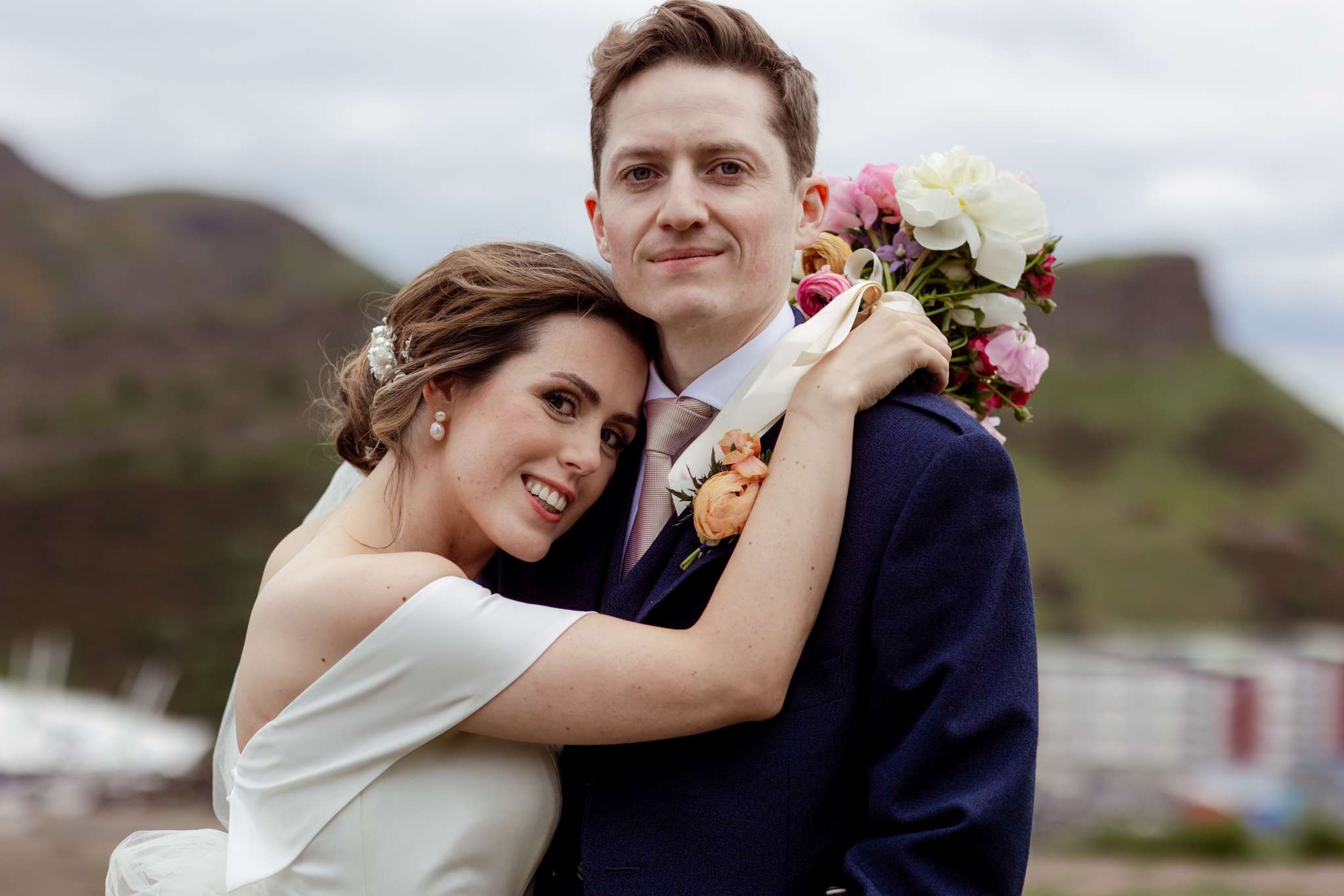 bride and groom embracing on top of Carlton Hill, Edinburgh 