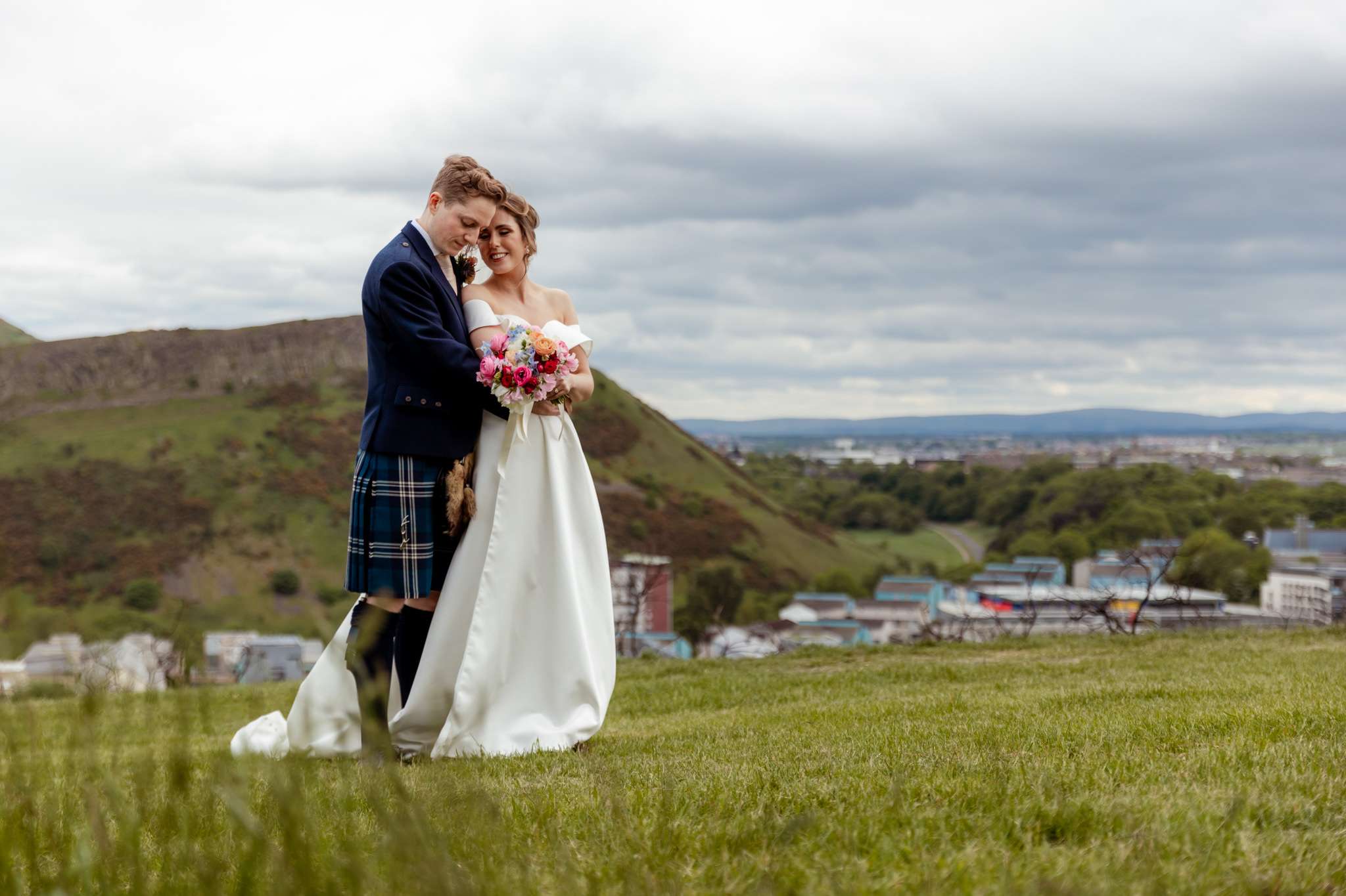 bride and groom embracing on top of Carlton Hill, Edinburgh 