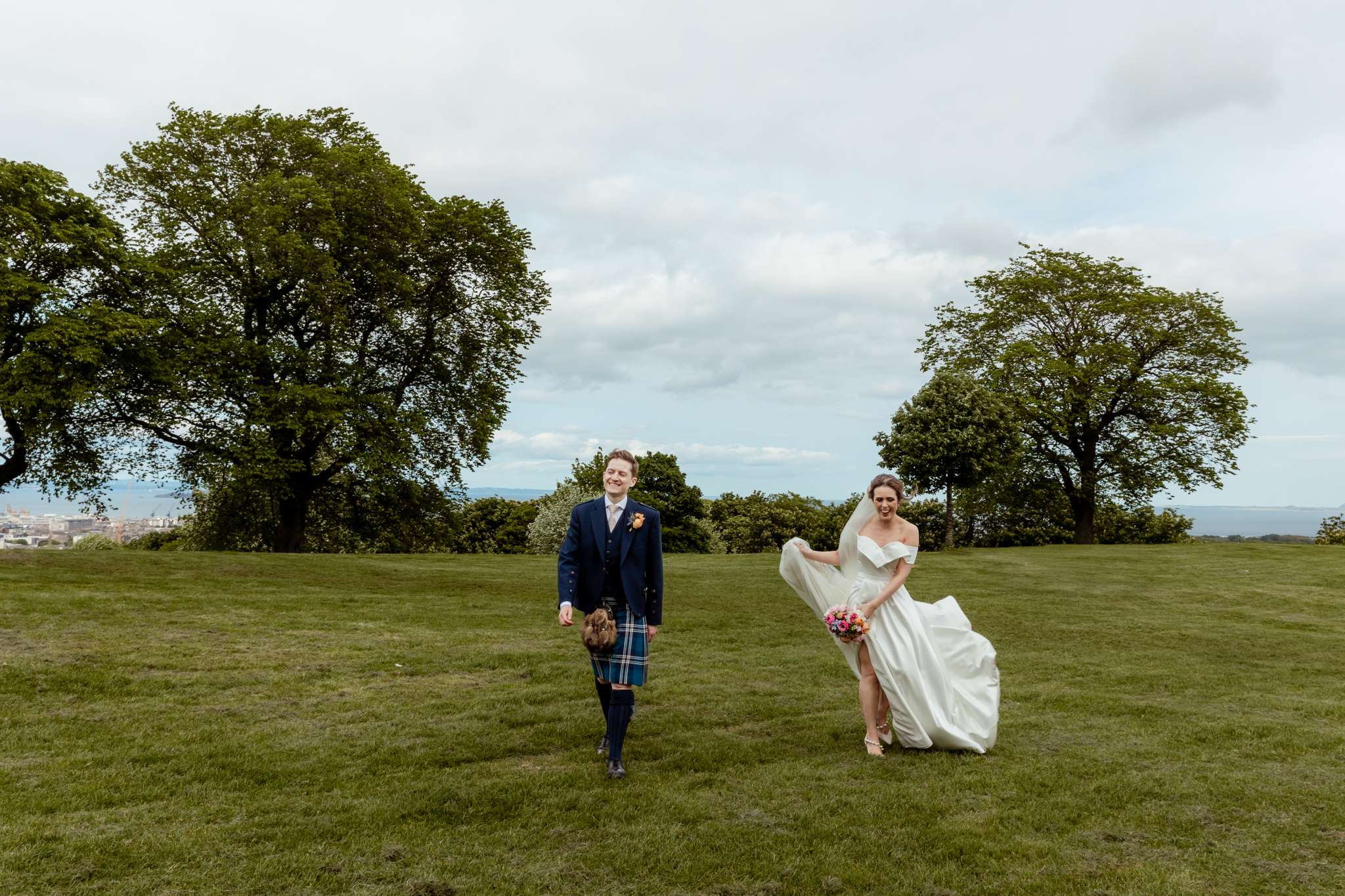 bride and groom walking along on top of Carlton Hill, Edinburgh 