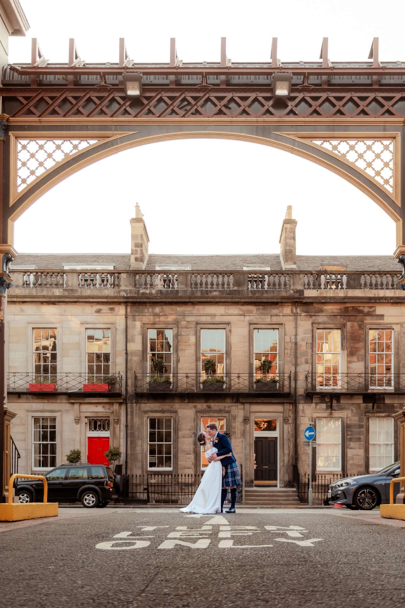 bride and groom under iron railway arches next to Caledonian Waldorf Hotel in Edinburgh 