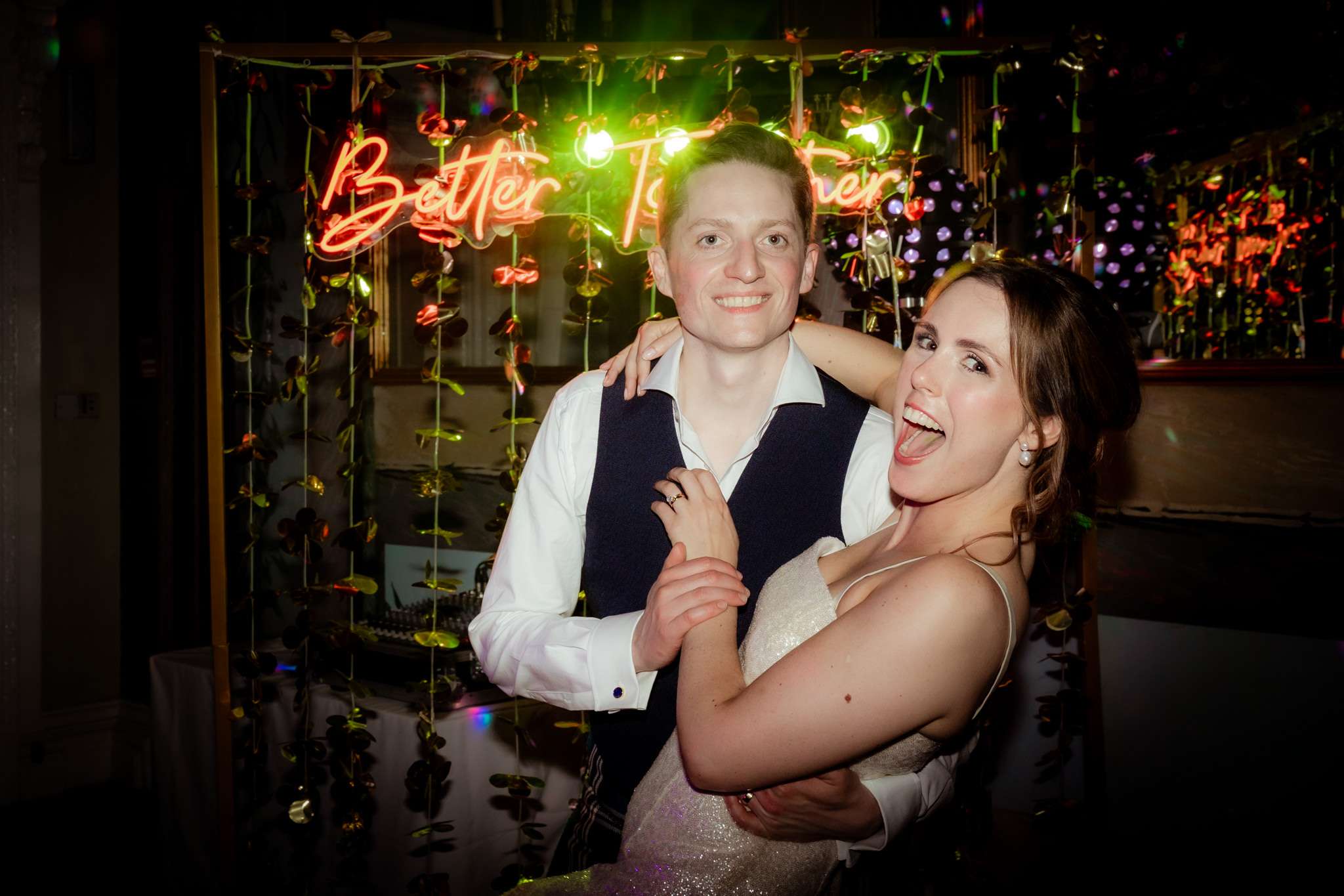 bride and groom posing in front of a neon light that says better together, at a wedding at Caledonian Waldorf Hotel in Edinburgh 