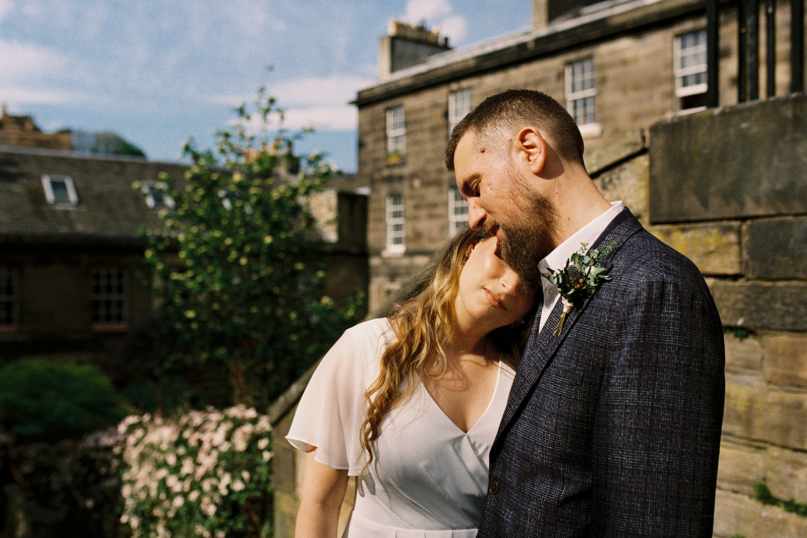 bride resting her head on the shoulder of her groom, at the Vennel steps in Edinburgh